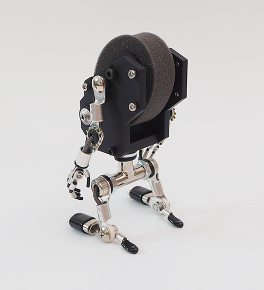 Black MiniMech robot watch stand with articulated metal limbs and gray felt-lined head display