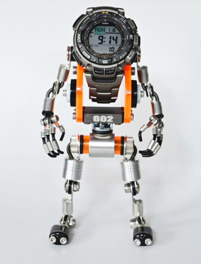 Digital watch standing in white and orange robot figure form with articulated limbs and mechanical details