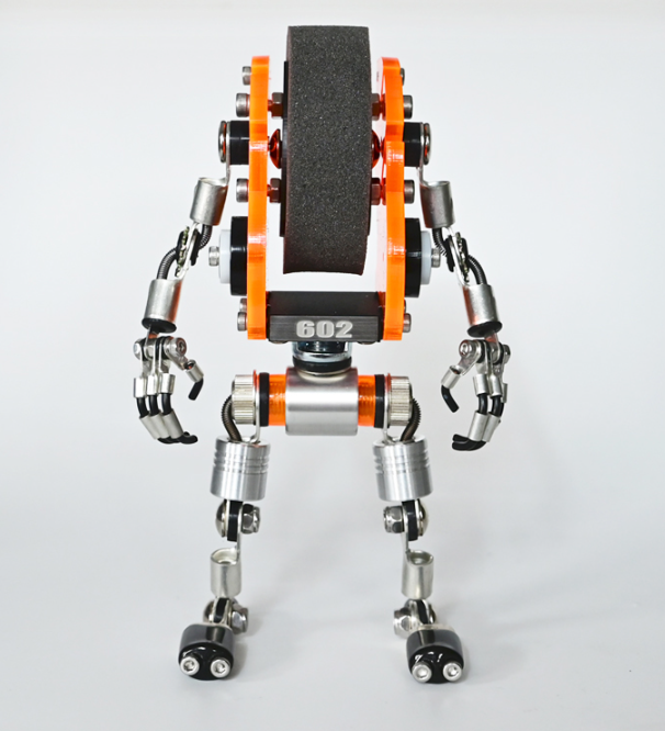 Orange and silver robotic watch stand with articulated metal limbs and gripper hands holding display