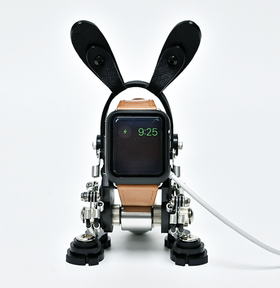 Black and tan robotic rabbit watch stand holder with articulated limbs and rabbit ear antenna for smartwatch display