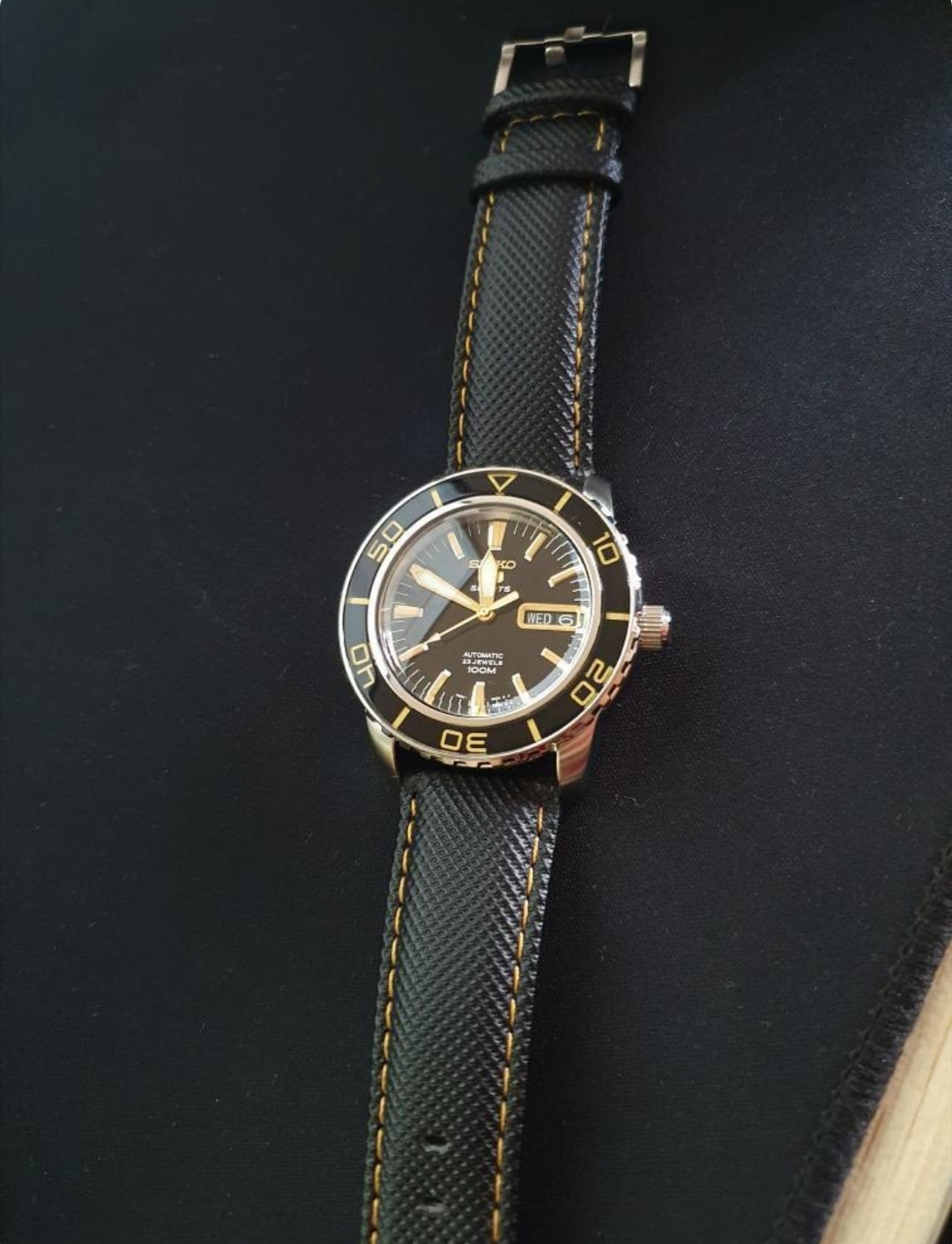 Black sailcloth watch strap with gold stitching and quick release buckle system