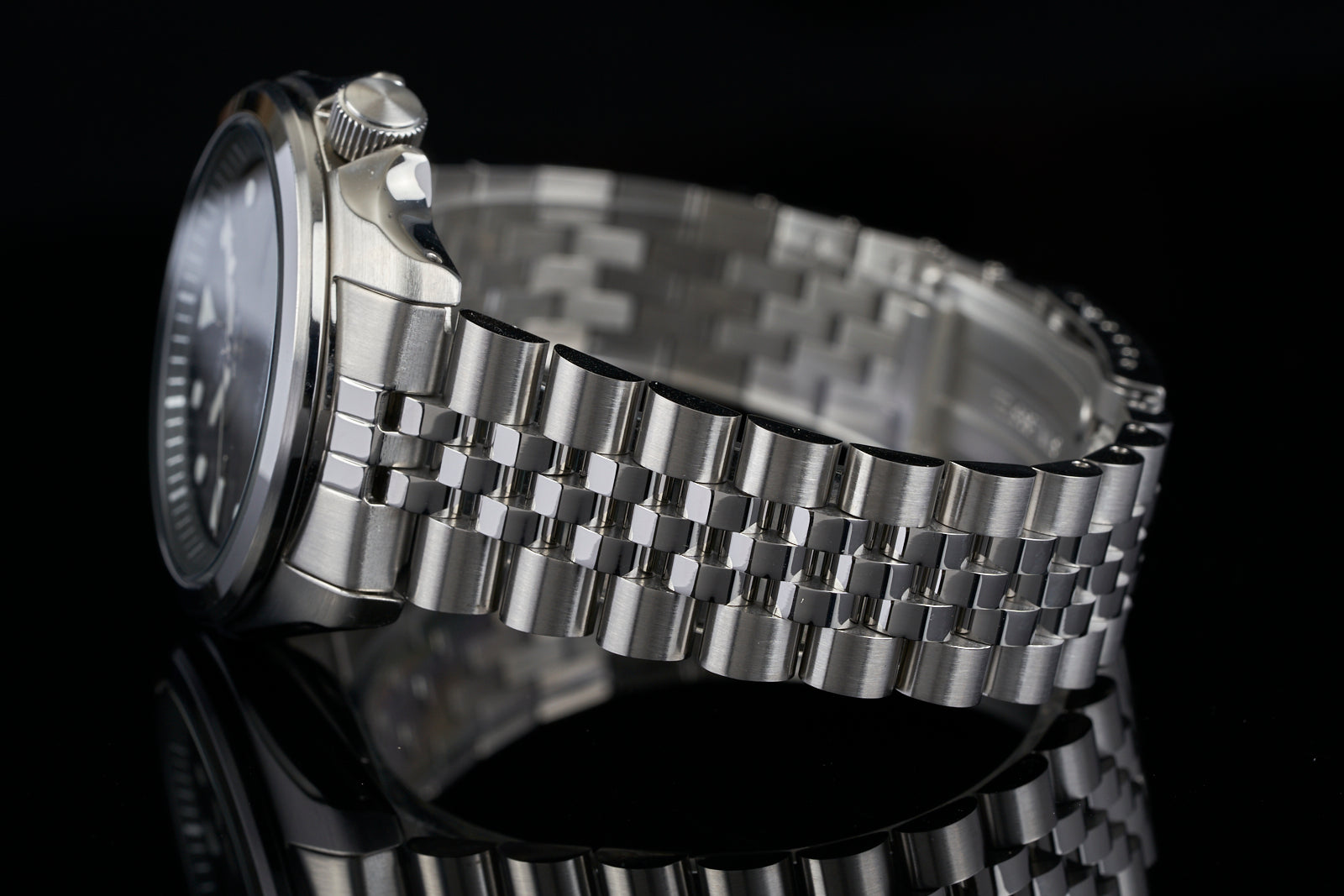 Seiko SRPE stainless steel dive watch with jubilee bracelet and black dial on black background