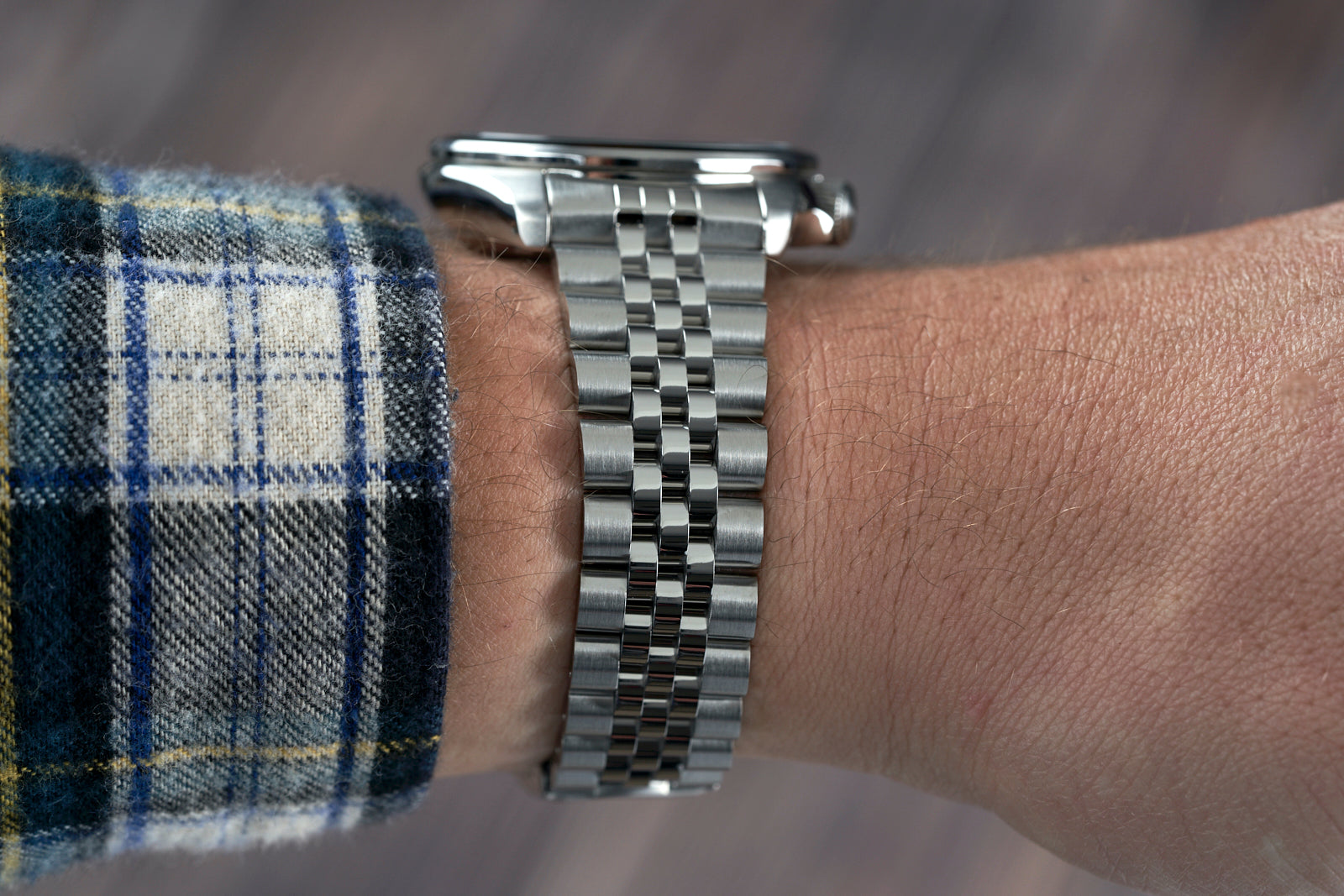 Seiko SRPE Executive watch with stainless steel jubilee bracelet worn on wrist with blue plaid shirt
