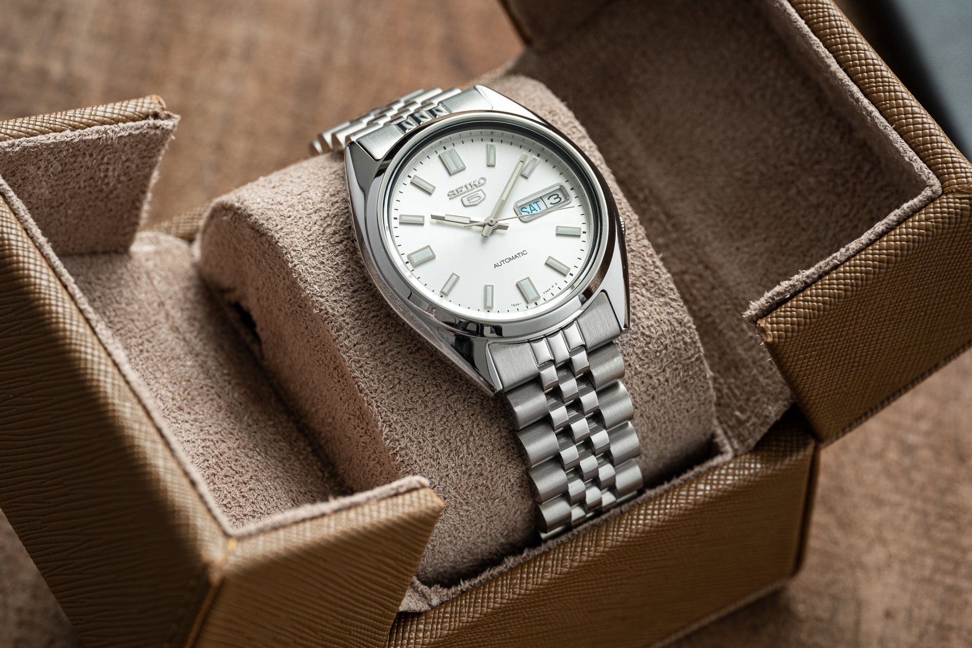 Seiko 5 SNXS automatic stainless steel watch with white dial and day-date window in presentation box