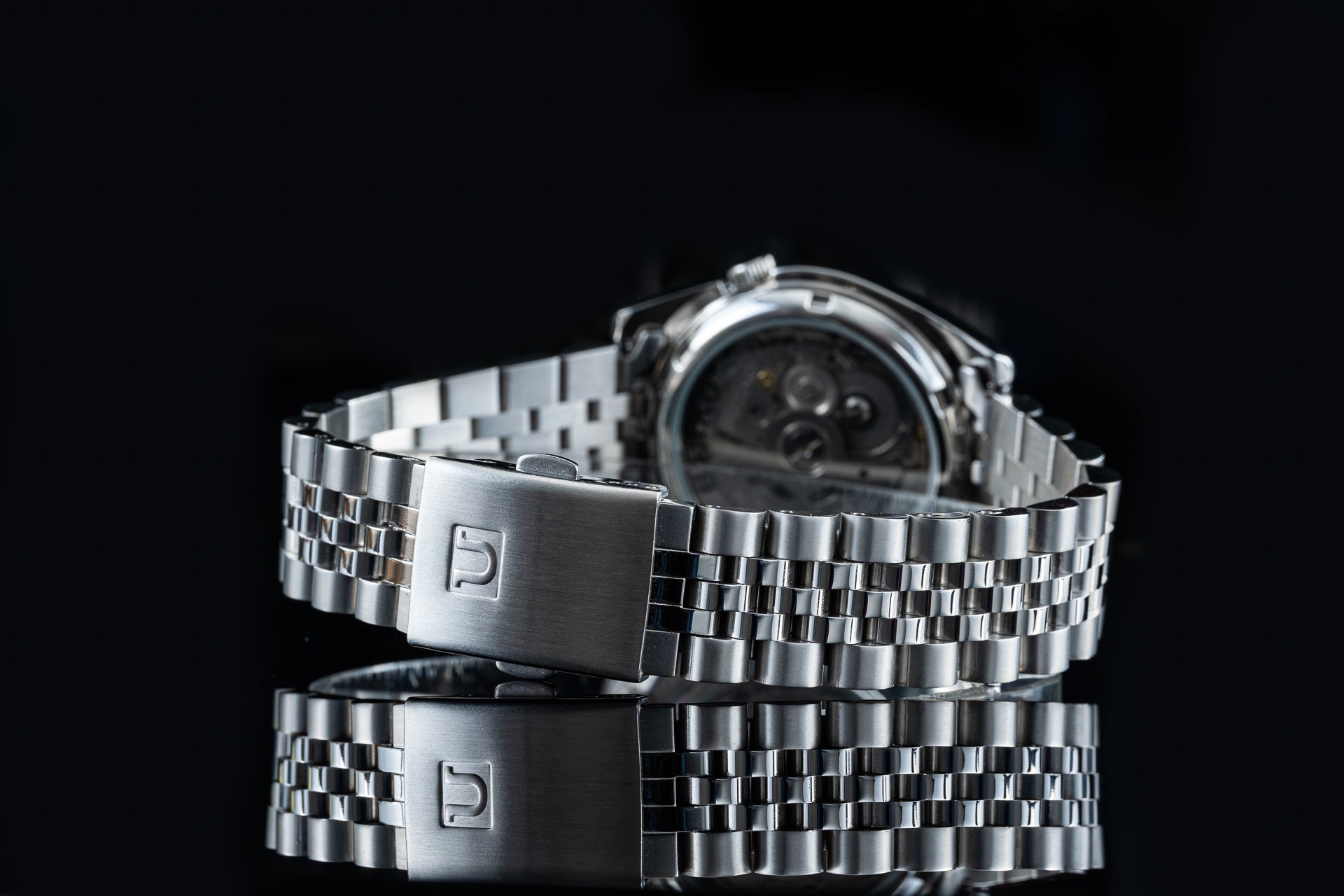 Seiko 5 SNKL stainless steel automatic watch with metal bracelet on black background