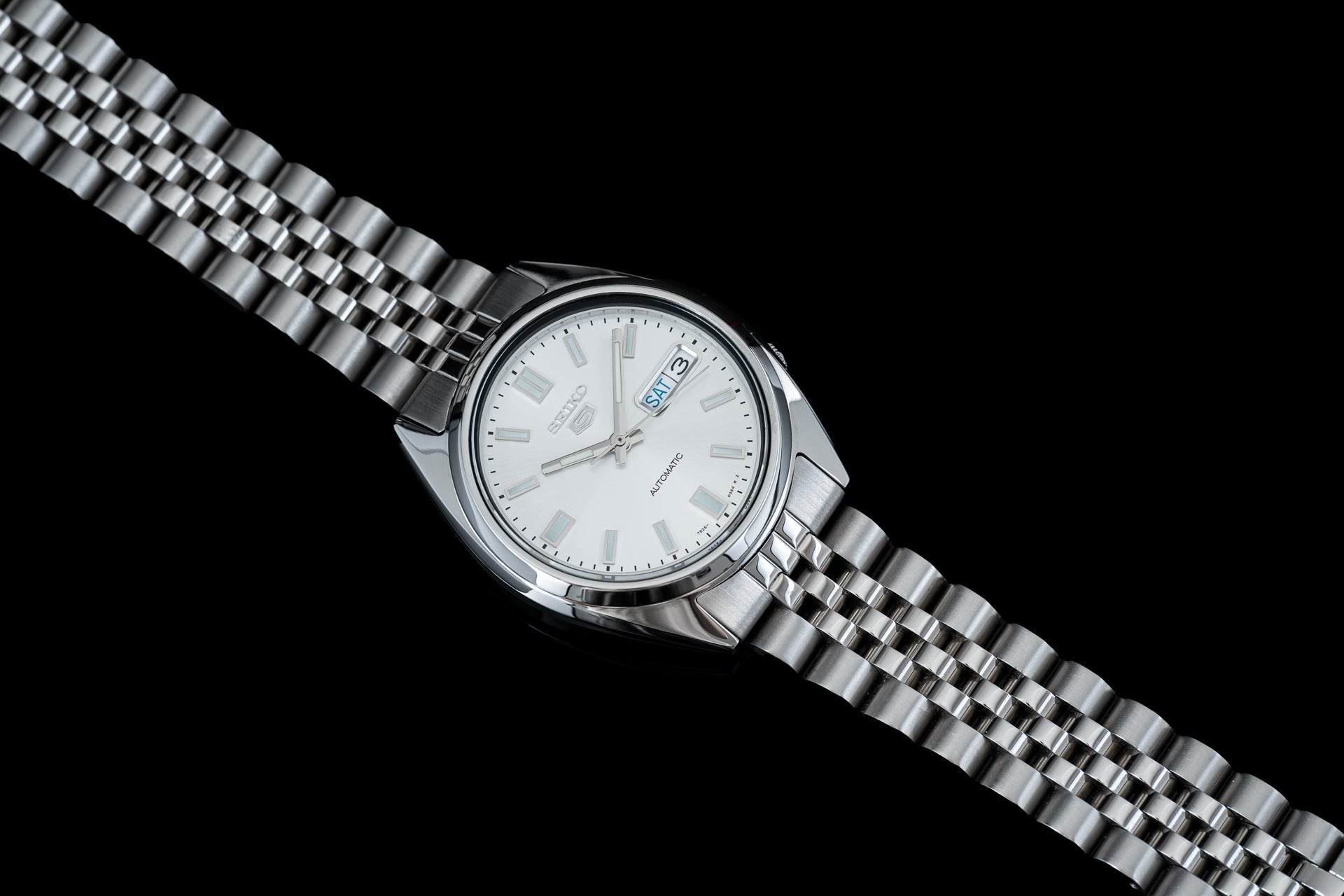 Seiko 5 SNXS automatic stainless steel watch with white dial and day-date window on metal bracelet