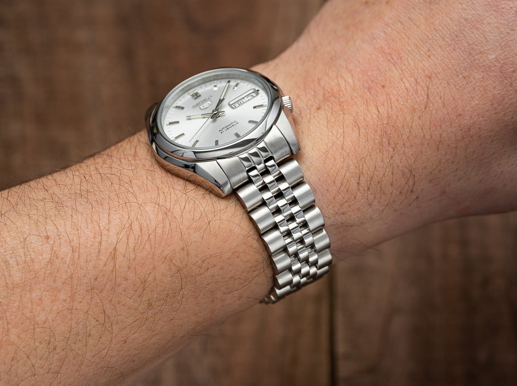 Seiko 5 SNKL automatic watch with white dial and day-date window on stainless steel jubilee bracelet worn on wrist