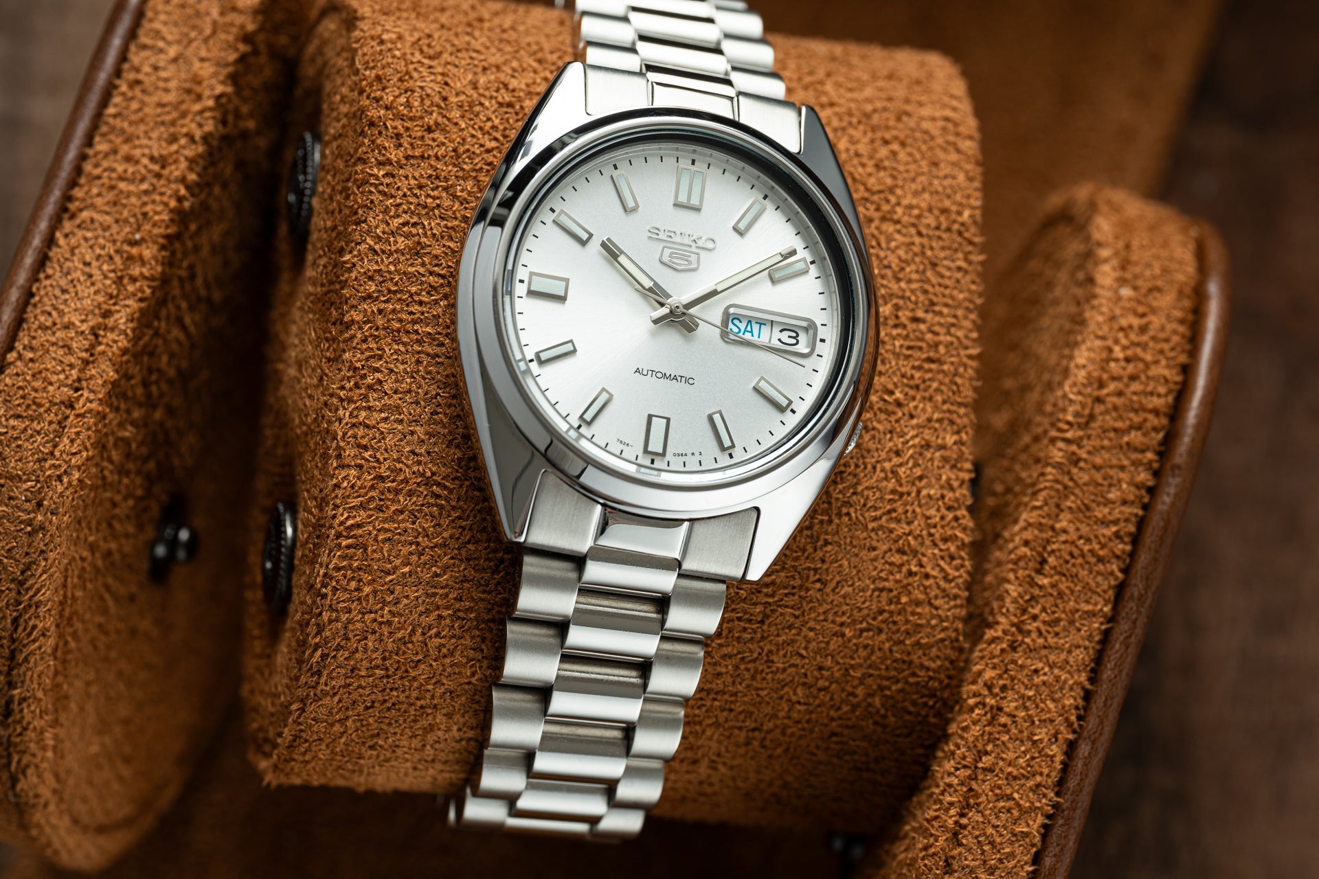 Seiko 5 SNXS automatic stainless steel watch with white dial and day-date window on brown leather display