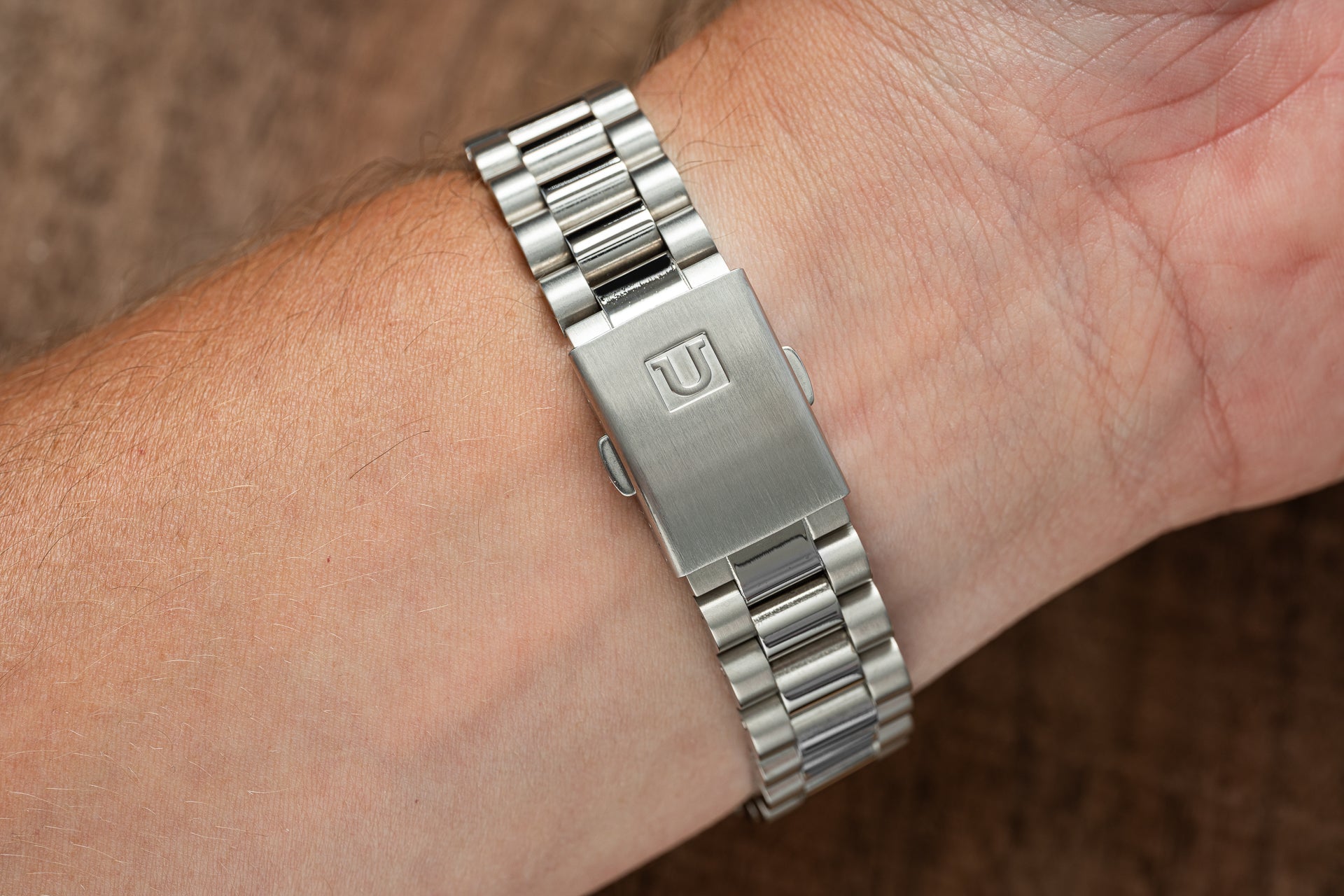 Stainless steel Uncle Lincoln bracelet for Seiko 5 SNXS watch worn on wrist, showcasing polished and brushed link design