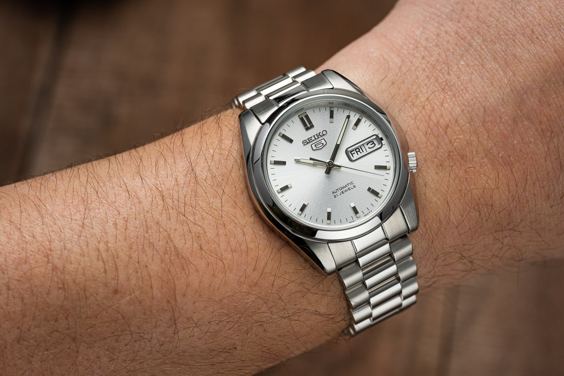 Seiko 5 SNKL automatic stainless steel watch with white dial and day-date window on wrist