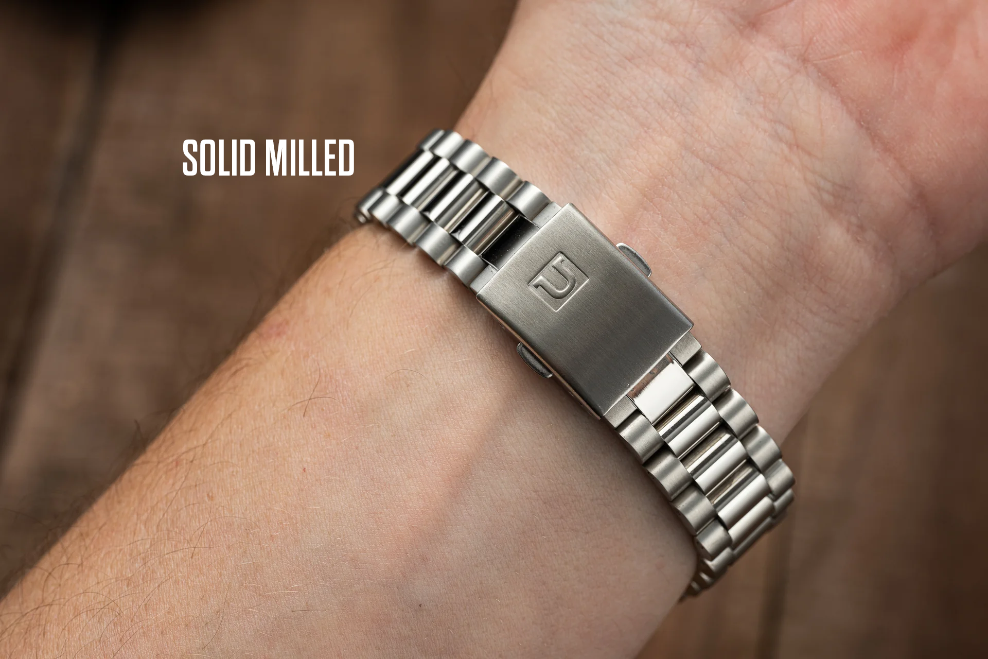 Solid milled stainless steel bracelet with rectangular clasp worn on wrist, compatible with Seiko SARB watches