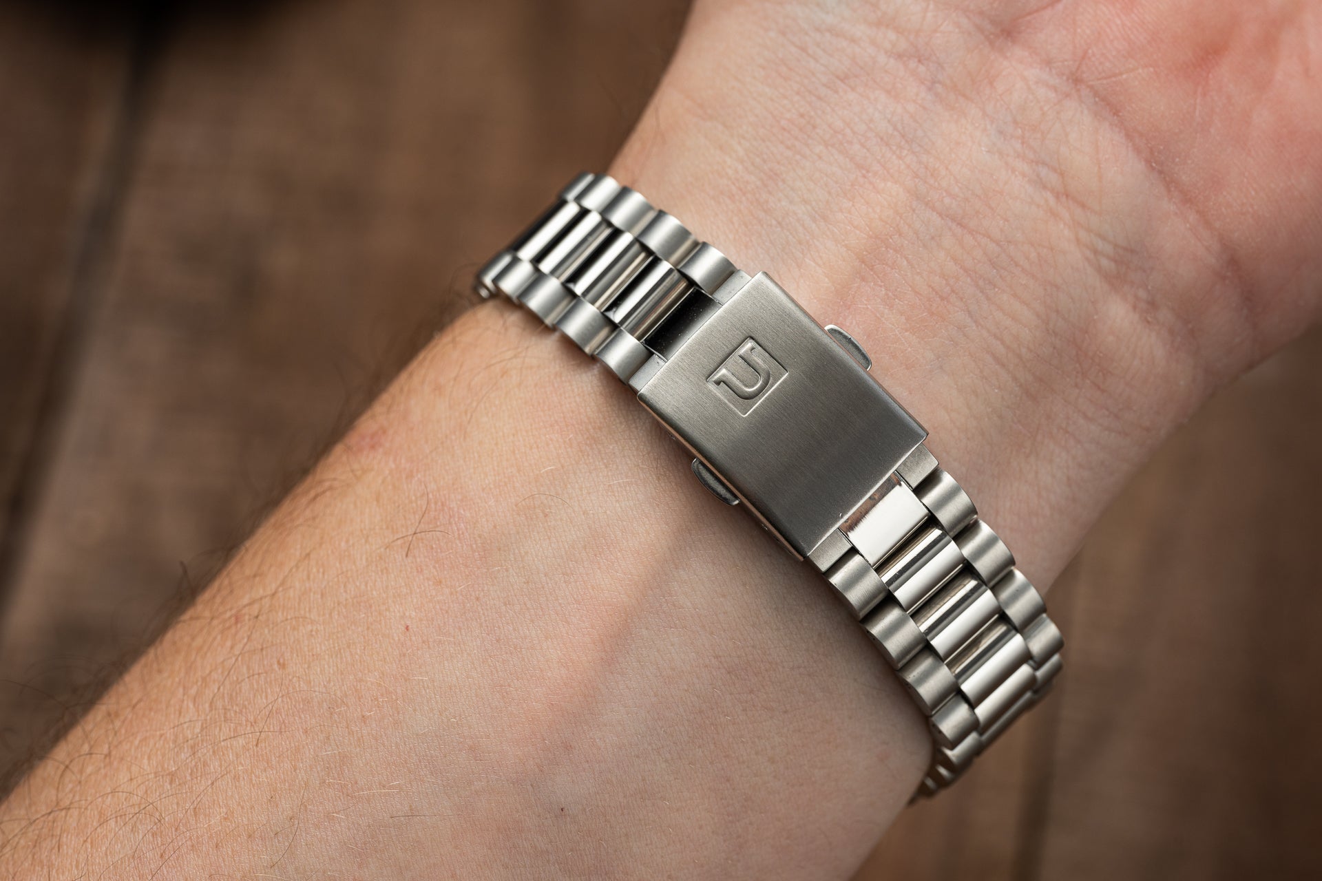 Stainless steel watch bracelet with rectangular face and link band worn on wrist, classic minimalist design