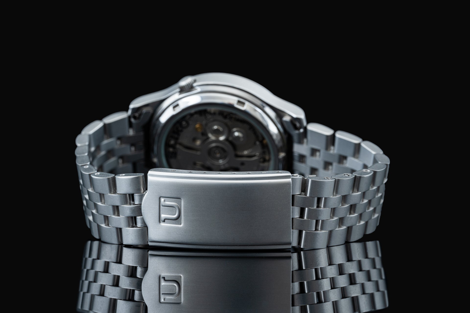 Silver stainless steel watch bracelet with fold-over clasp, back view showing watch head attachment