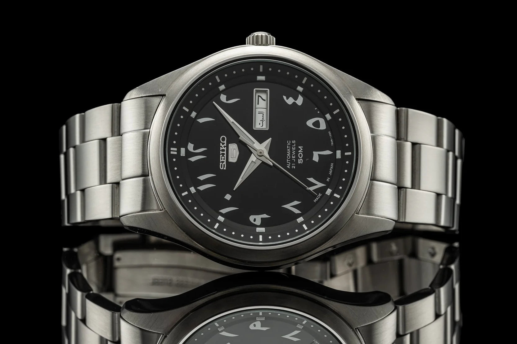 Seiko 5 automatic watch with stainless steel bracelet, black dial, Arabic numerals, and day-date window
