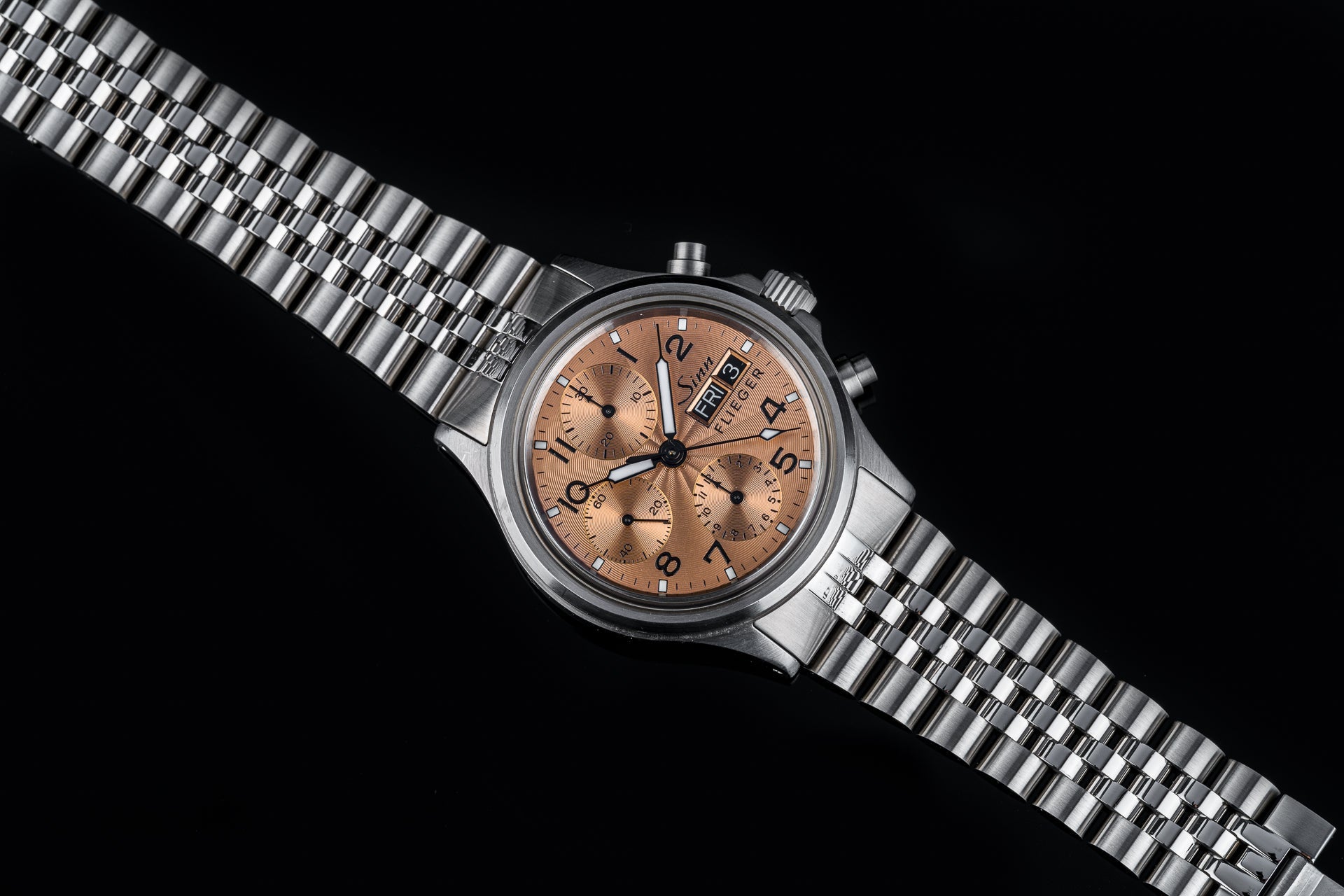 Sinn Flieger 356 chronograph watch with copper dial and stainless steel bracelet on black background