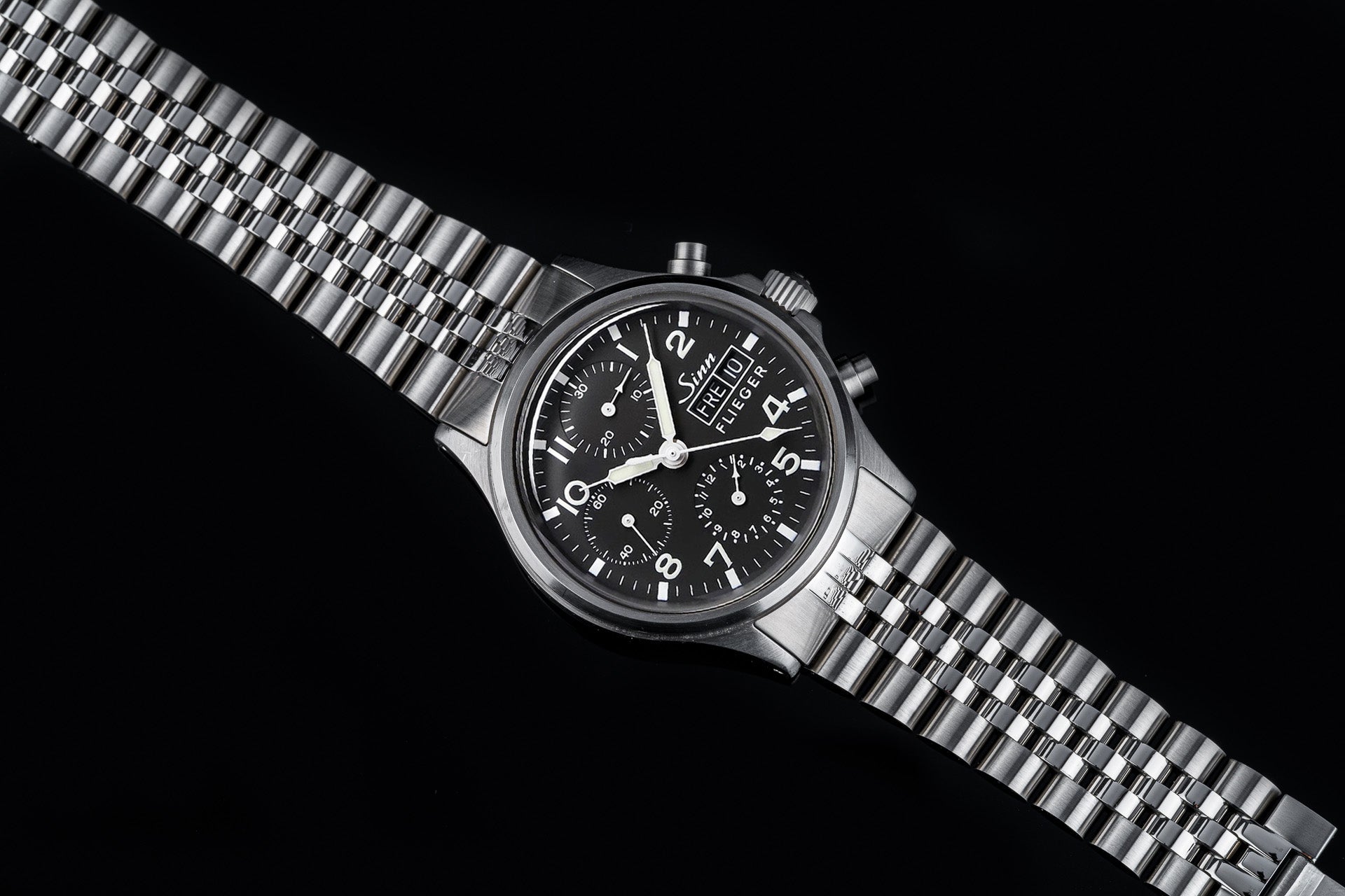 Sinn Flieger 356 chronograph watch with black dial, stainless steel bracelet and case on black background