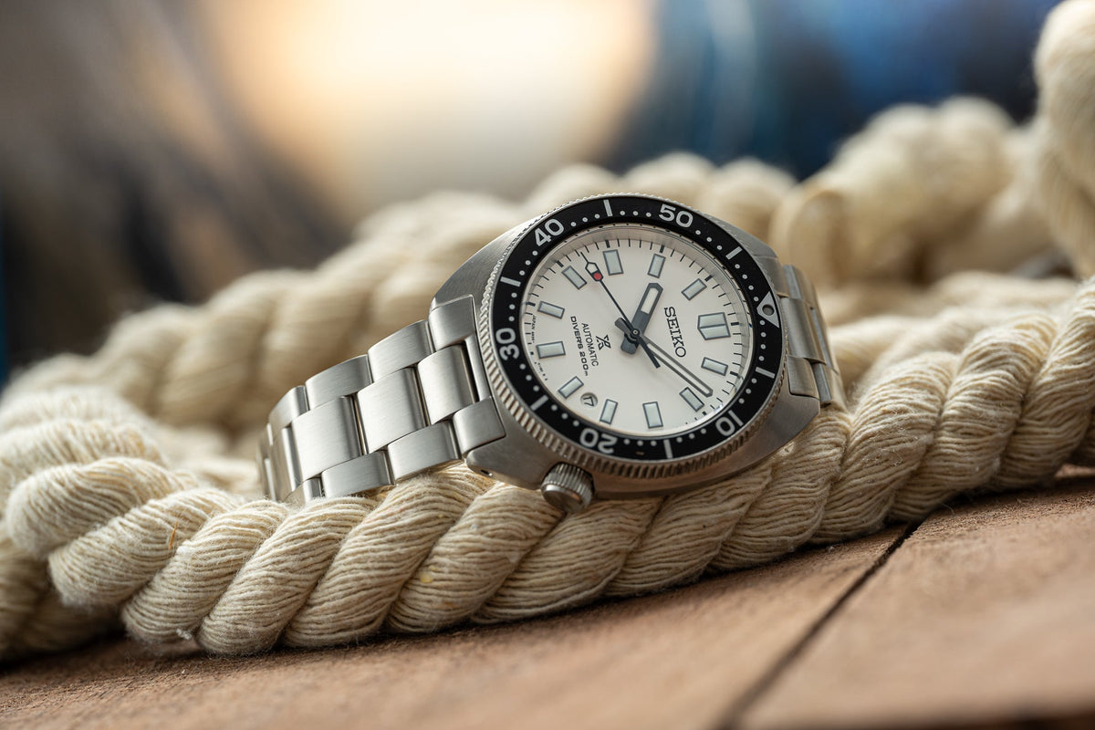 Seiko Prospex stainless steel dive watch with white dial and black bezel on rope background