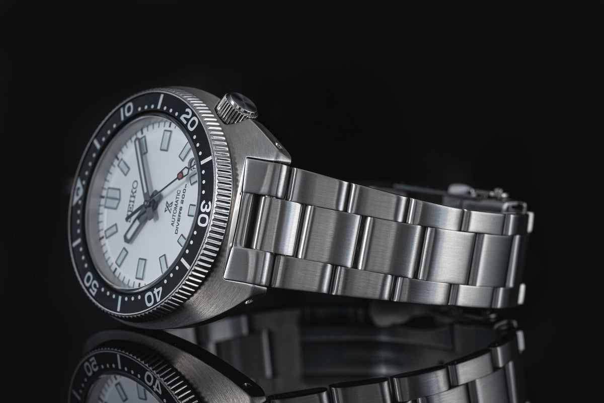 Seiko SPB31x Slim Turtle automatic watch with stainless steel bracelet and black bezel on dark background