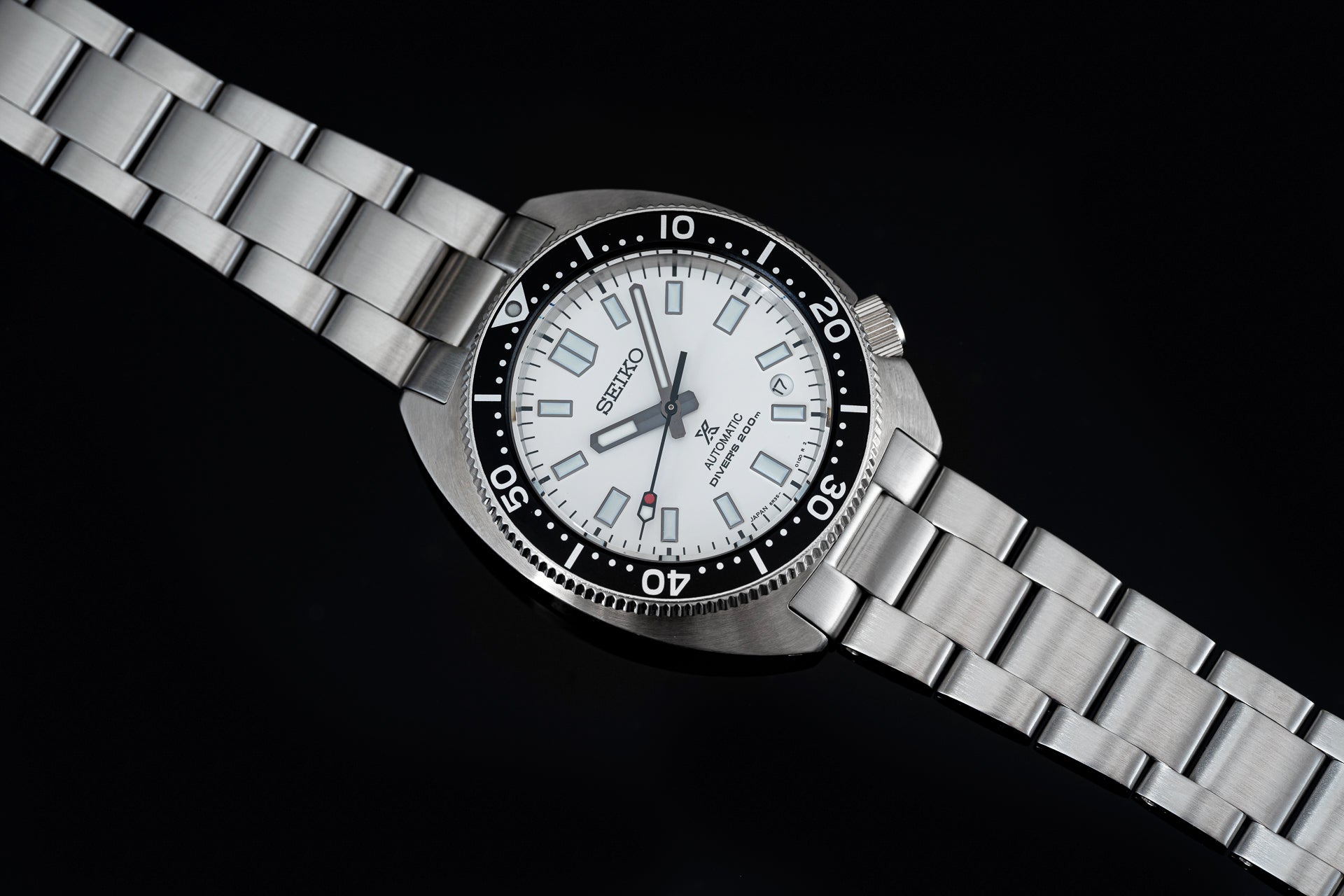 Seiko Prospex Slim Turtle automatic dive watch with stainless steel bracelet and white dial on black background