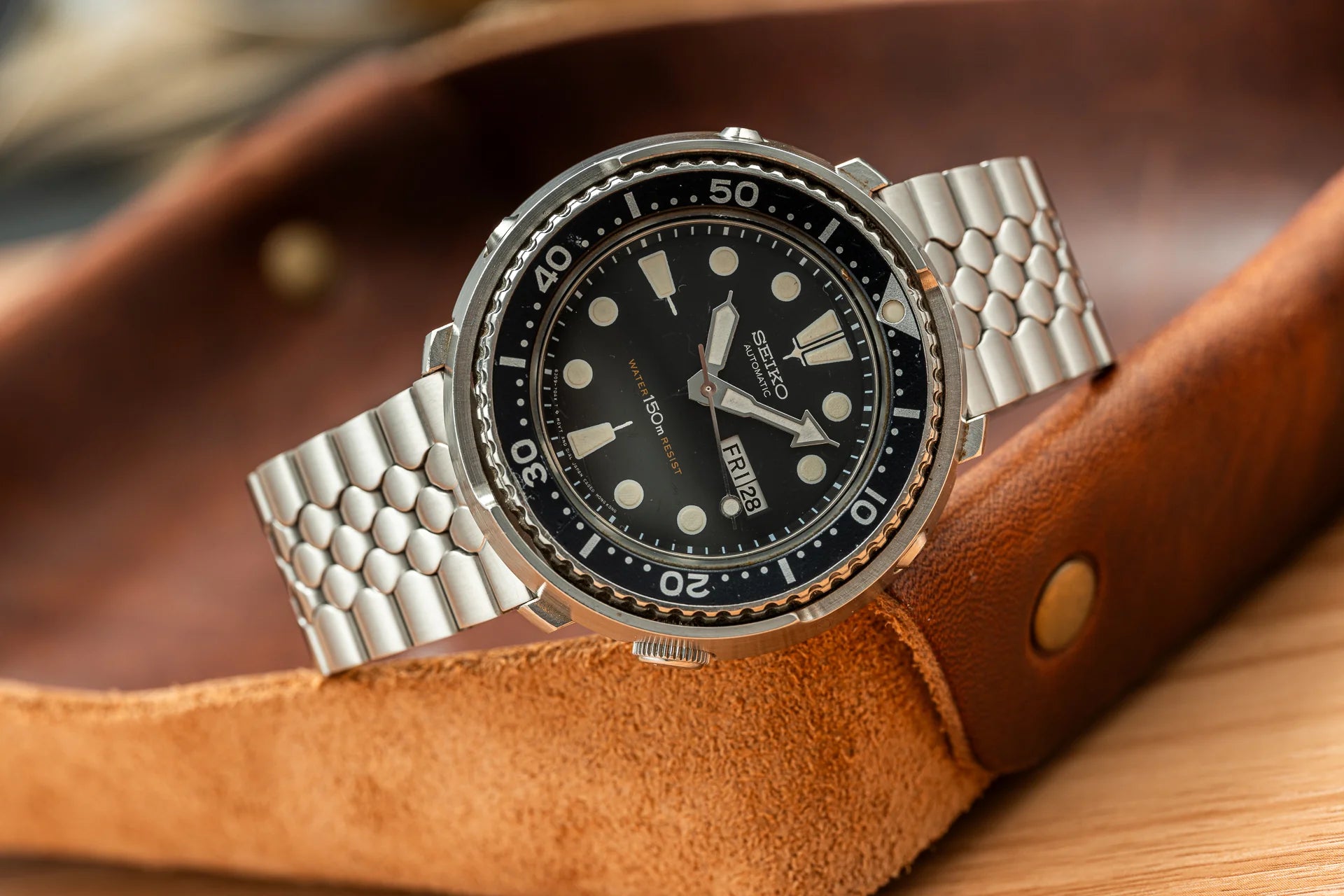 Seiko dive watch with stainless steel bracelet and black dial on brown leather strap