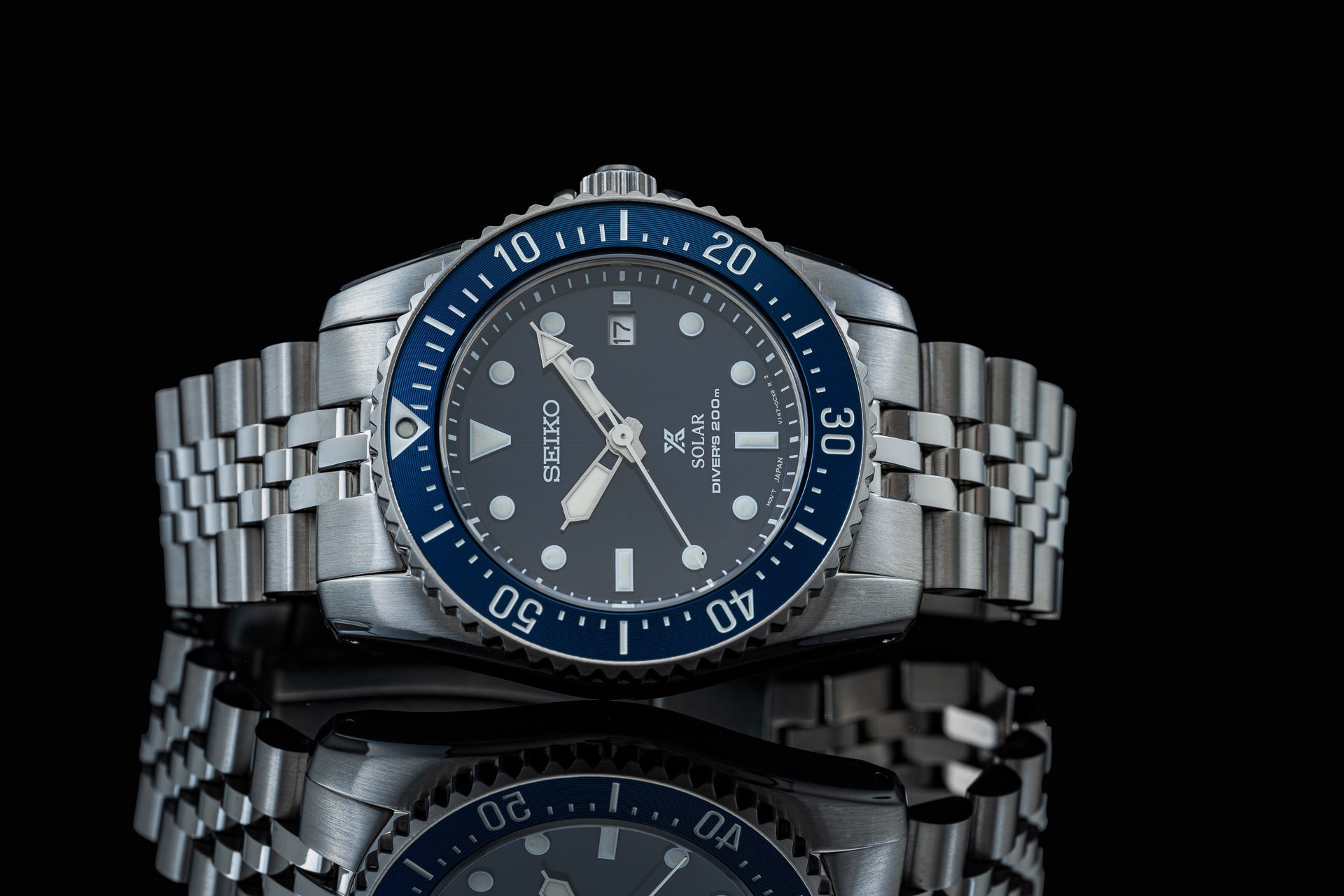 Seiko SNE575 solar diver watch with blue rotating bezel, dark gray dial, stainless steel bracelet and date window