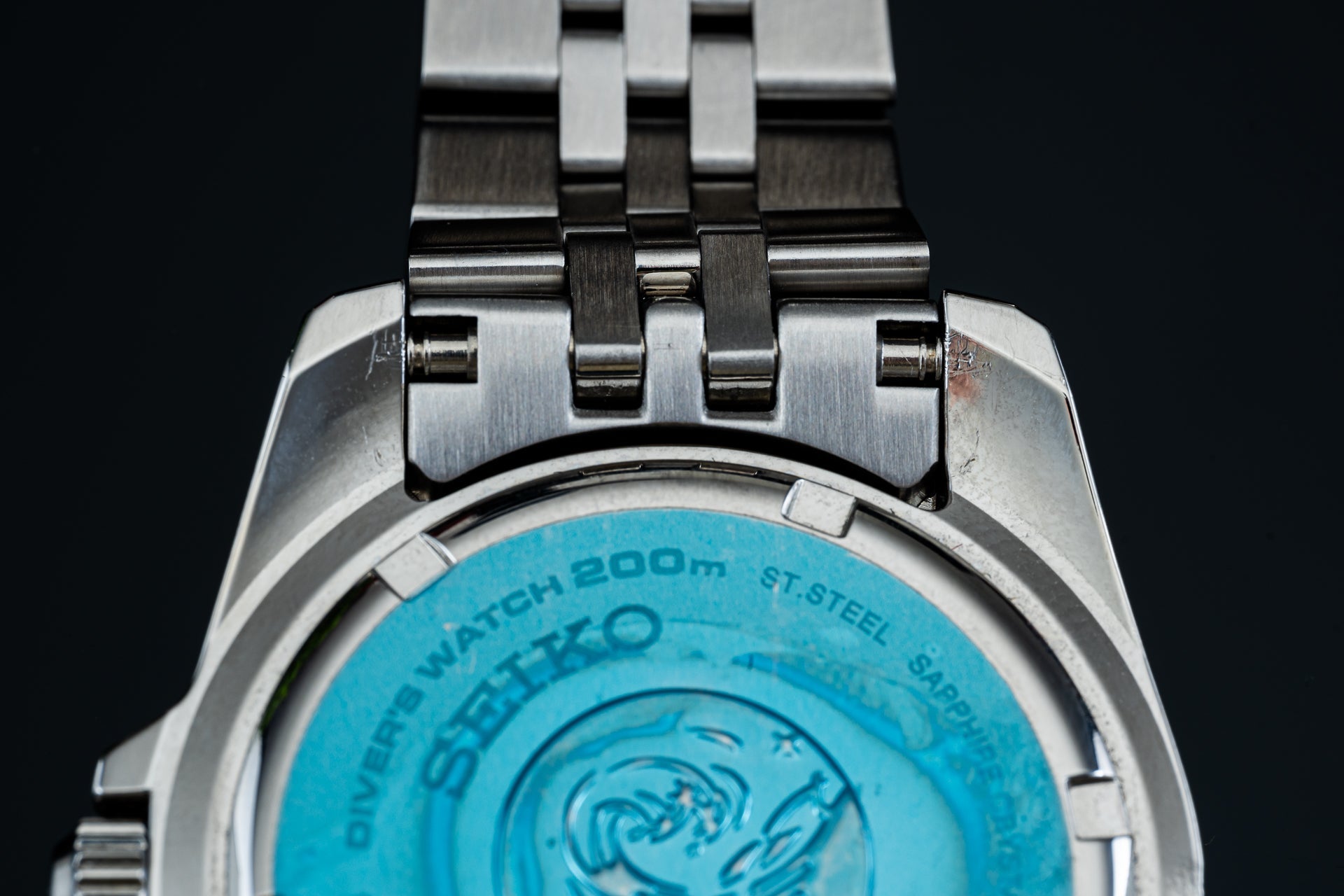 Seiko stainless steel solar watch with metal bracelet and blue dial, showing case back detail with 200m water resistance marking