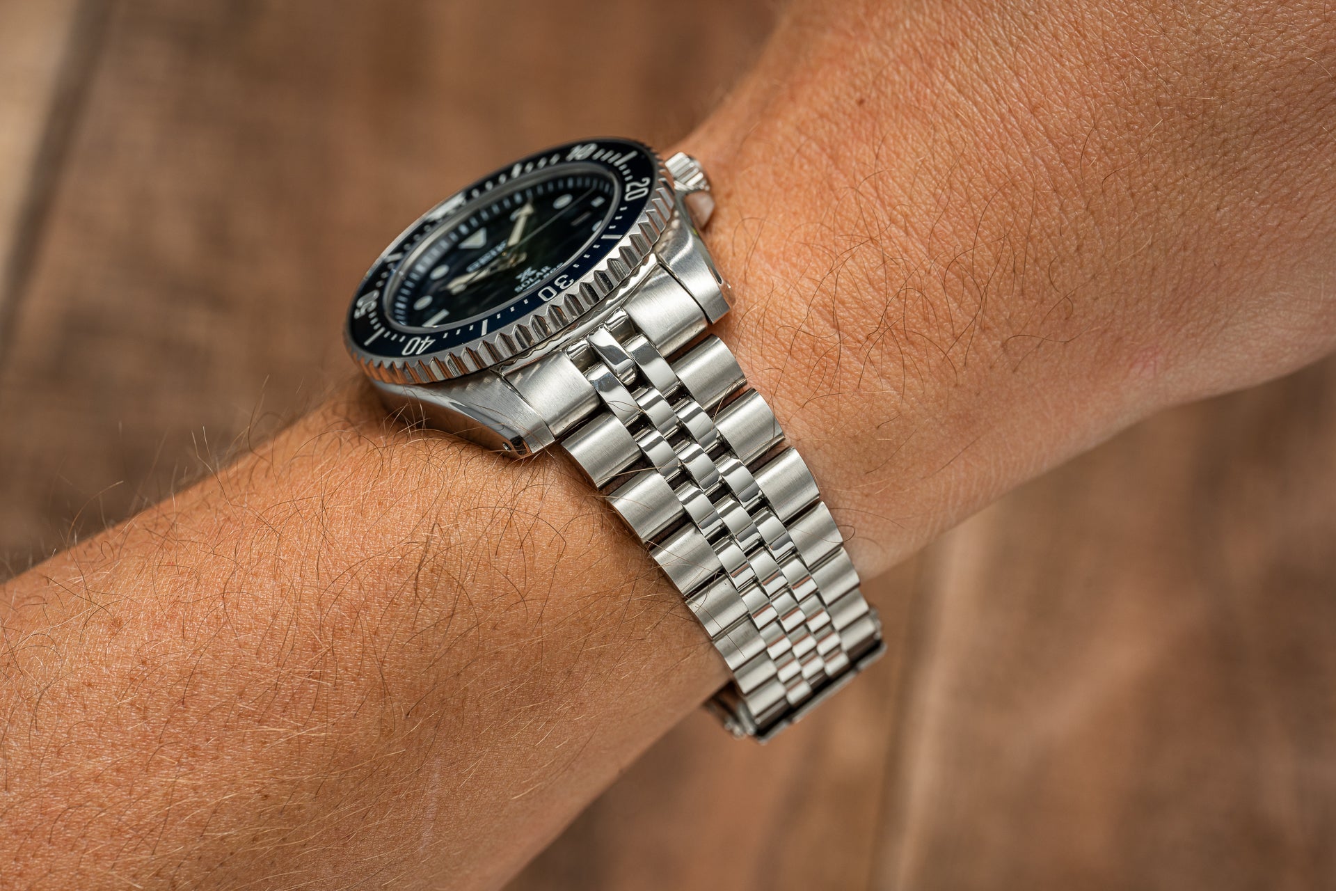 Seiko SNE57x Solar dive watch with black dial and stainless steel bracelet worn on wrist