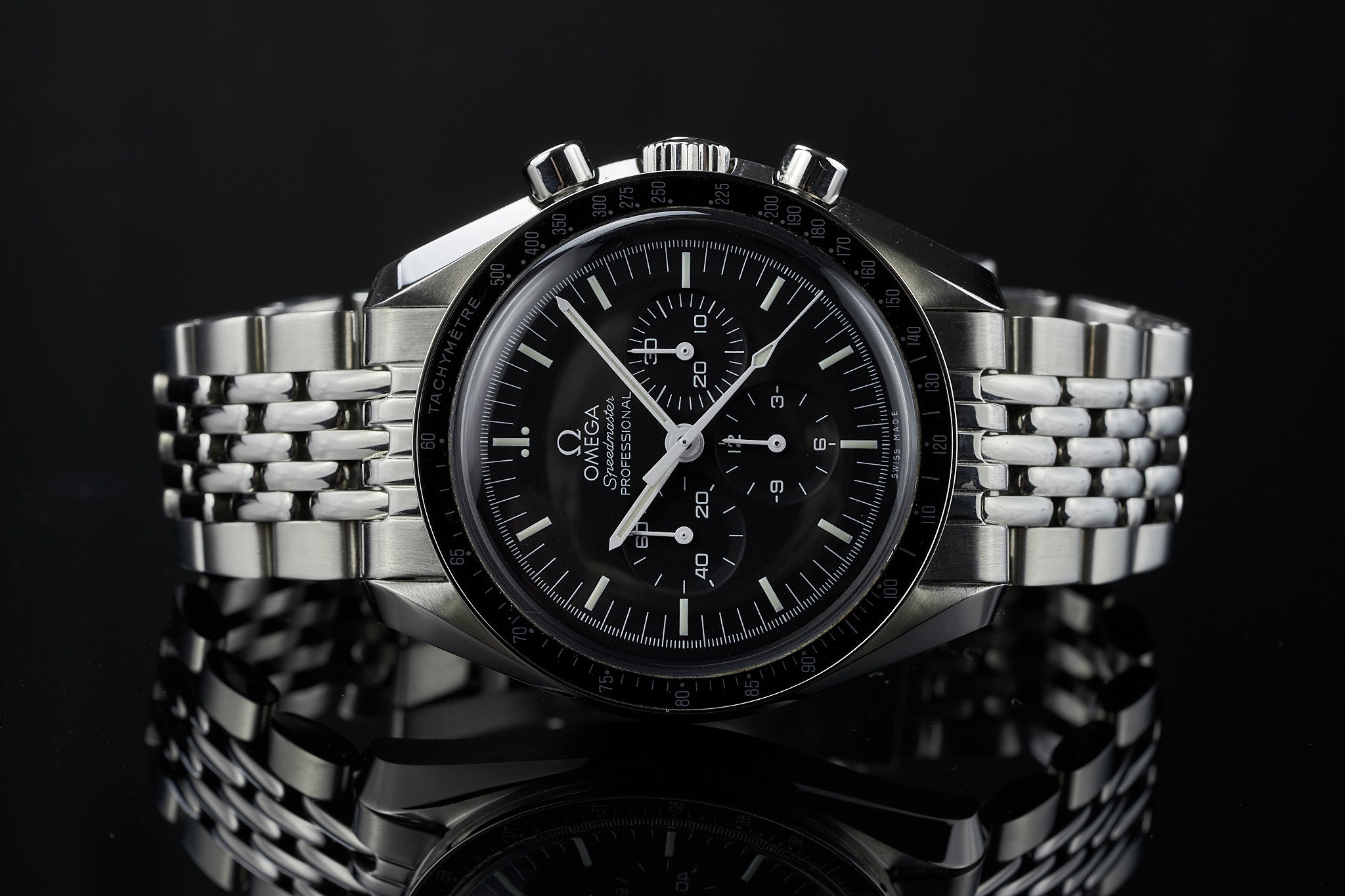 Omega Speedmaster chronograph watch with black dial, stainless steel Beads of Rice bracelet, tachymeter bezel on black background