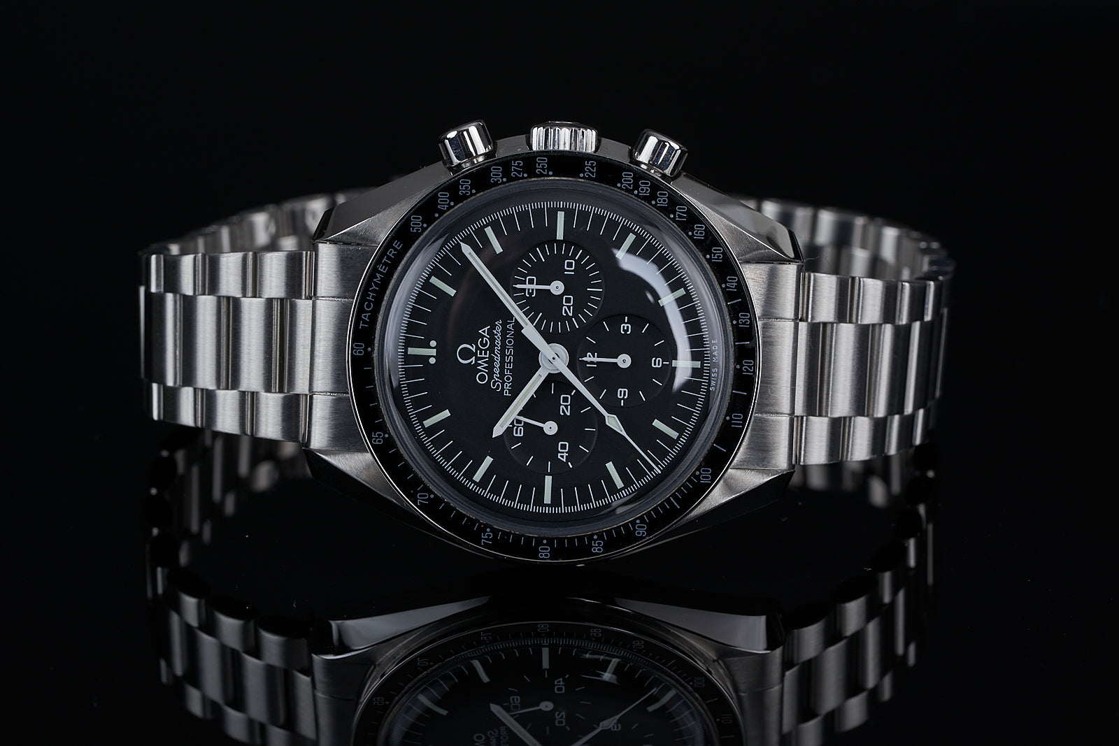 Omega Speedmaster professional chronograph watch with steel bracelet and black dial on reflective black background