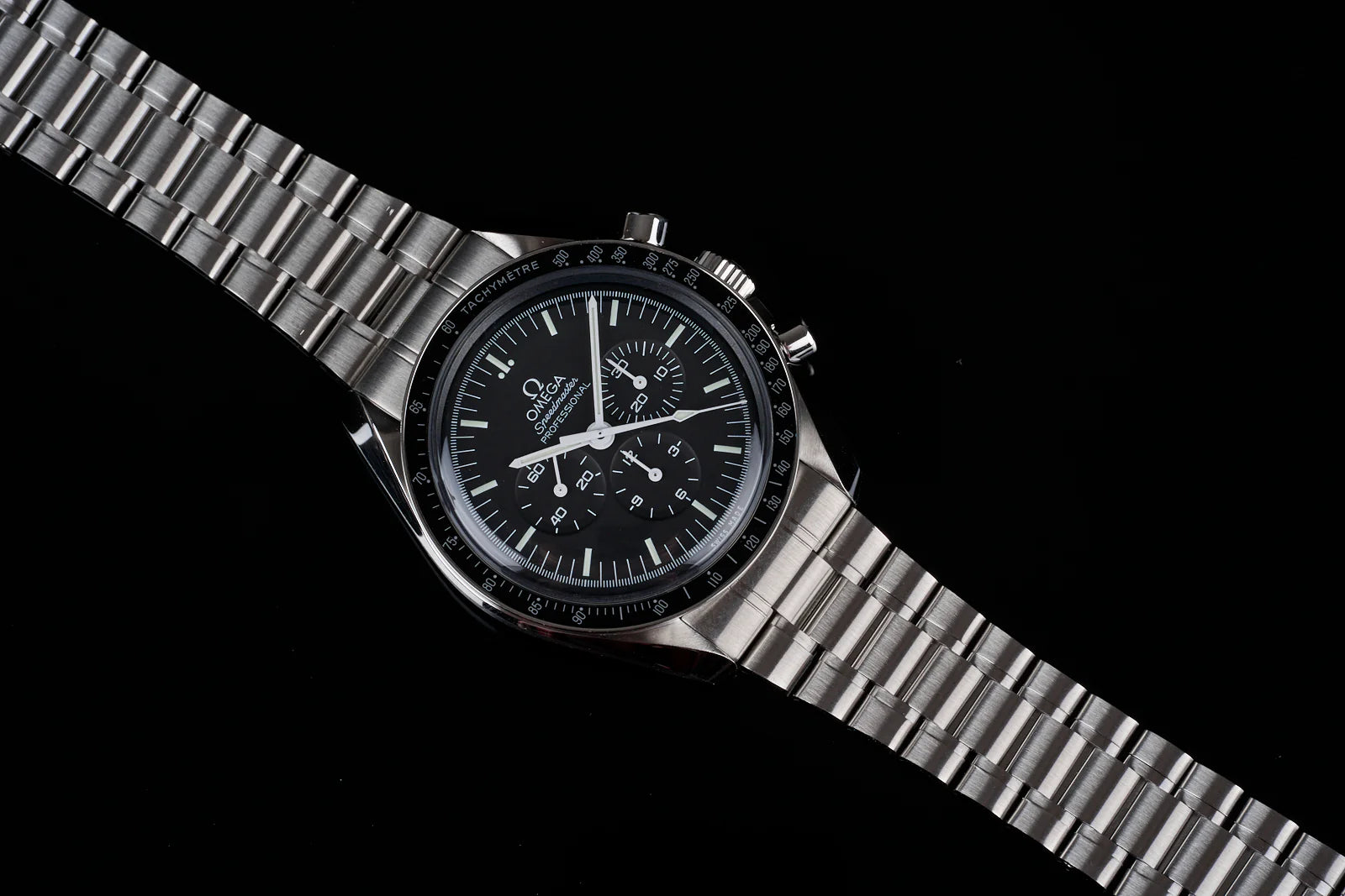 Omega Speedmaster Professional chronograph watch with black dial, stainless steel bracelet and tachymeter bezel on black background