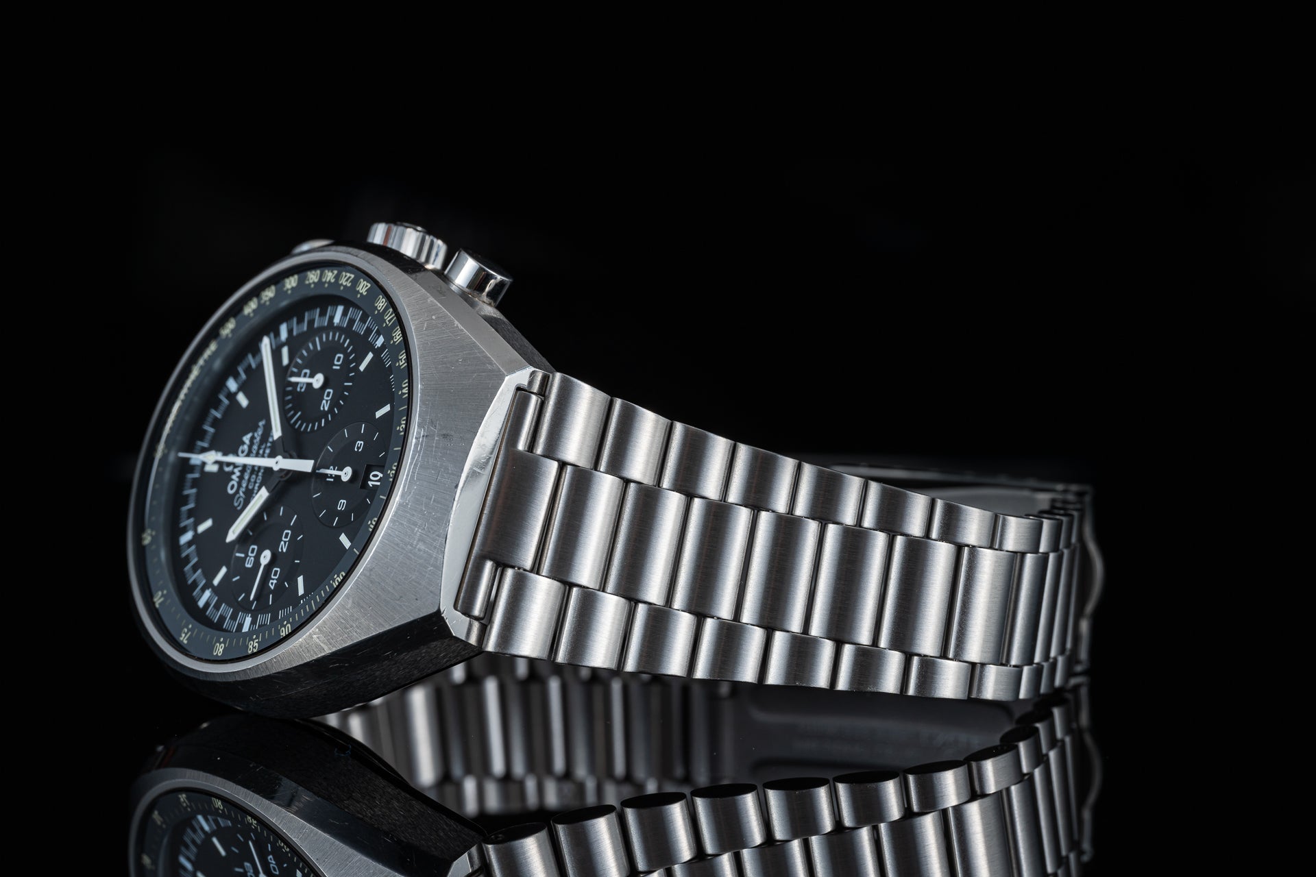 Omega Speedmaster Mark II chronograph watch with black dial and stainless steel bracelet on black background