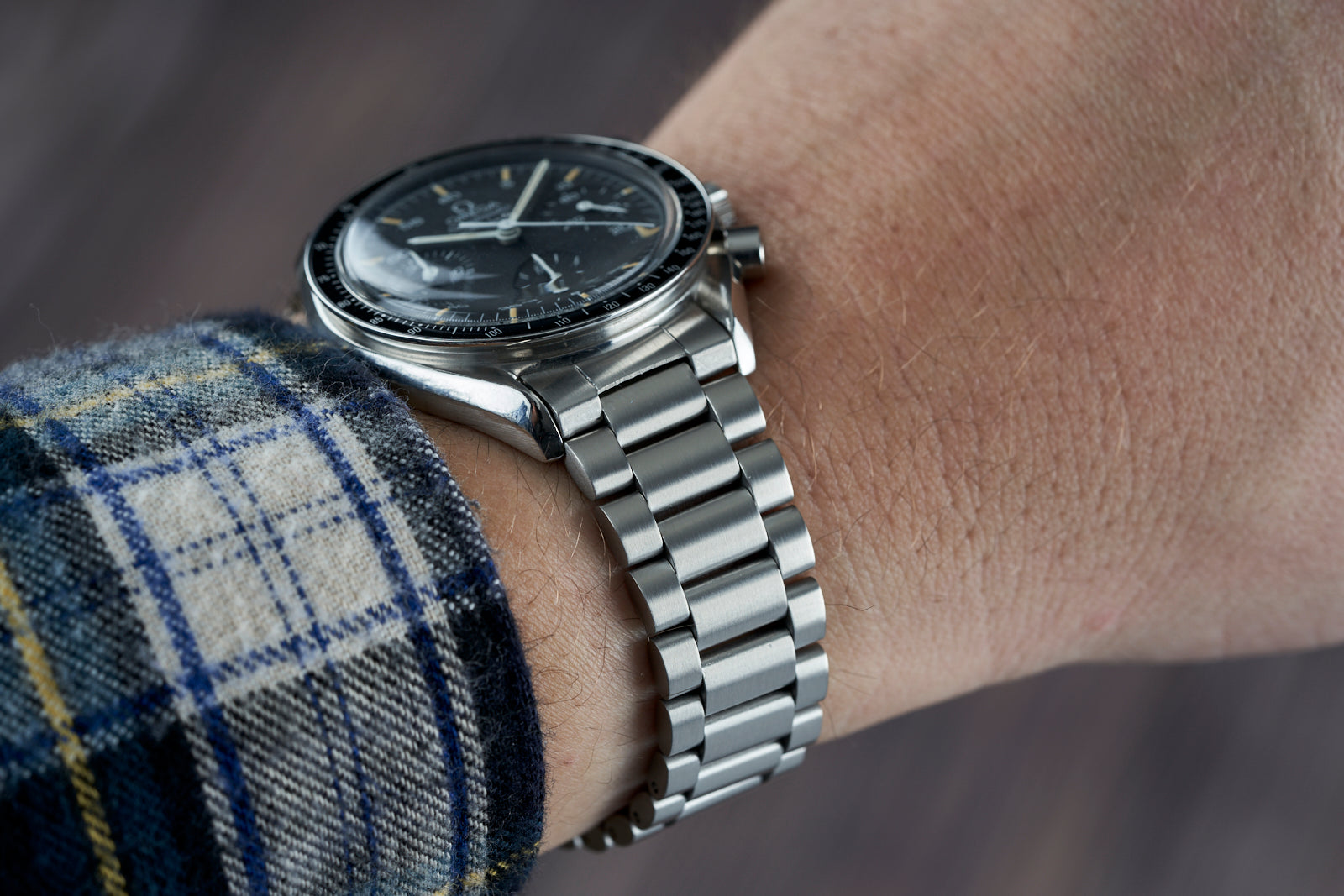 Stainless steel bracelet for Omega Speedmaster Reduced watch on wrist with black dial and chronograph subdials