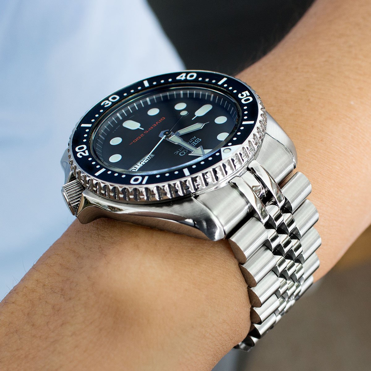 Stainless steel dive watch with black dial and rotating bezel on Super-J Louis Jub bracelet, worn on wrist