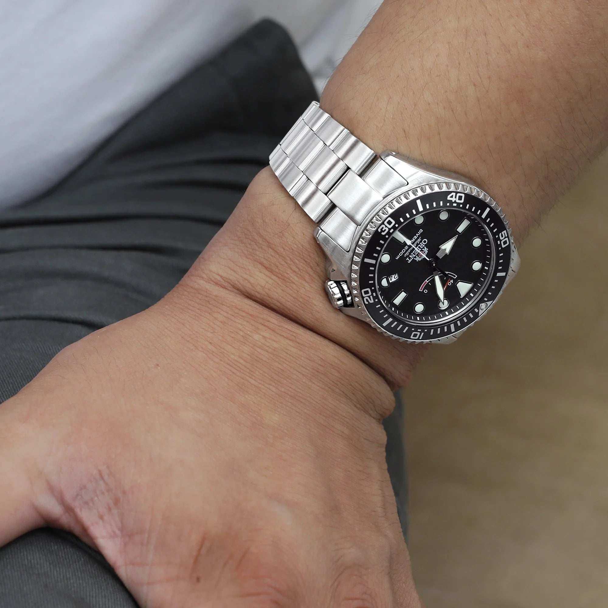 Silver stainless steel Super-O Boyer bracelet on black dial dive watch with GMT bezel worn on wrist