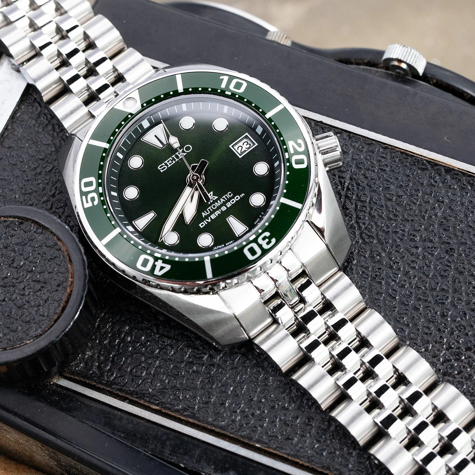 Seiko Sumo diver watch with green bezel and stainless steel Angus-J Louis bracelet on black leather watch case