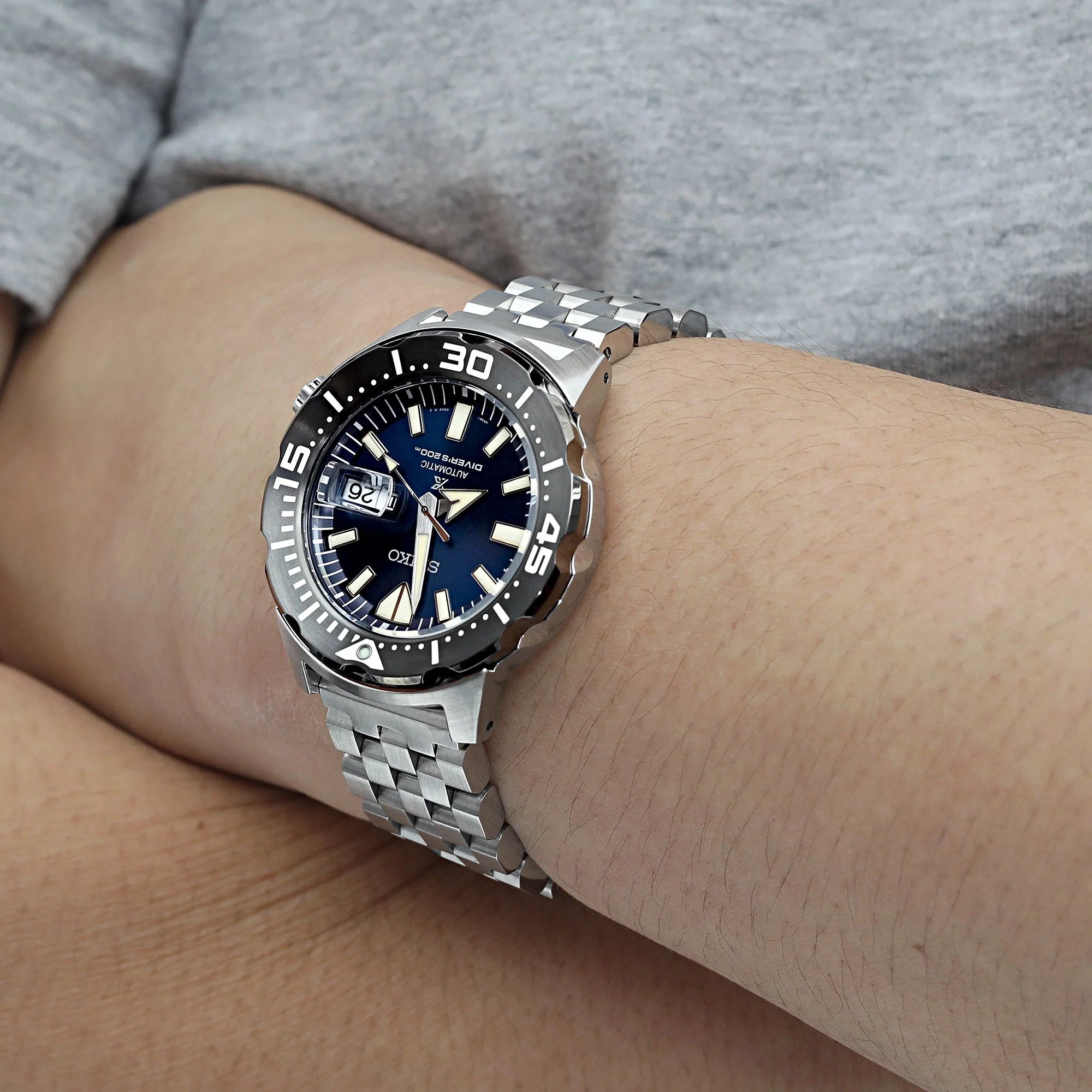 Stainless steel dive watch with blue dial and rotating bezel on Engineer bracelet with V-clasp, worn on wrist