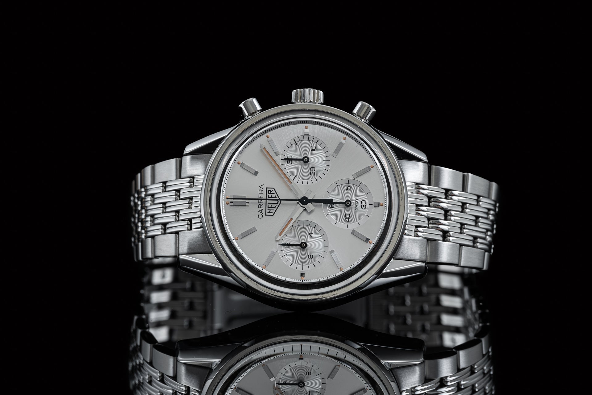 Silver stainless steel chronograph watch with white dial, three subdials, and matching Beads of Rice bracelet on black background