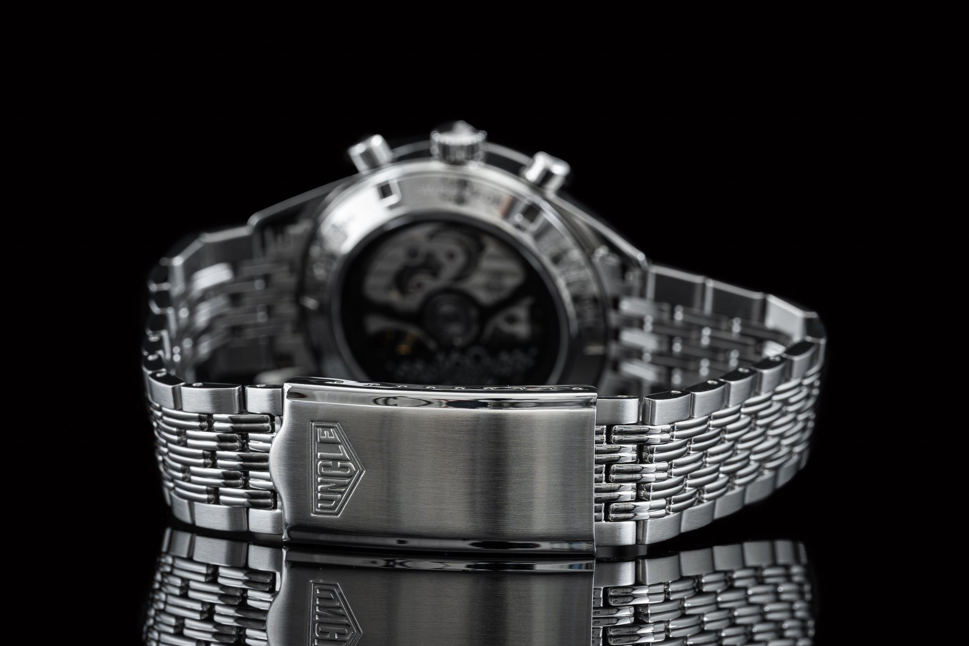 Silver stainless steel digital chronograph watch with beads of rice bracelet and brushed metal clasp on black background