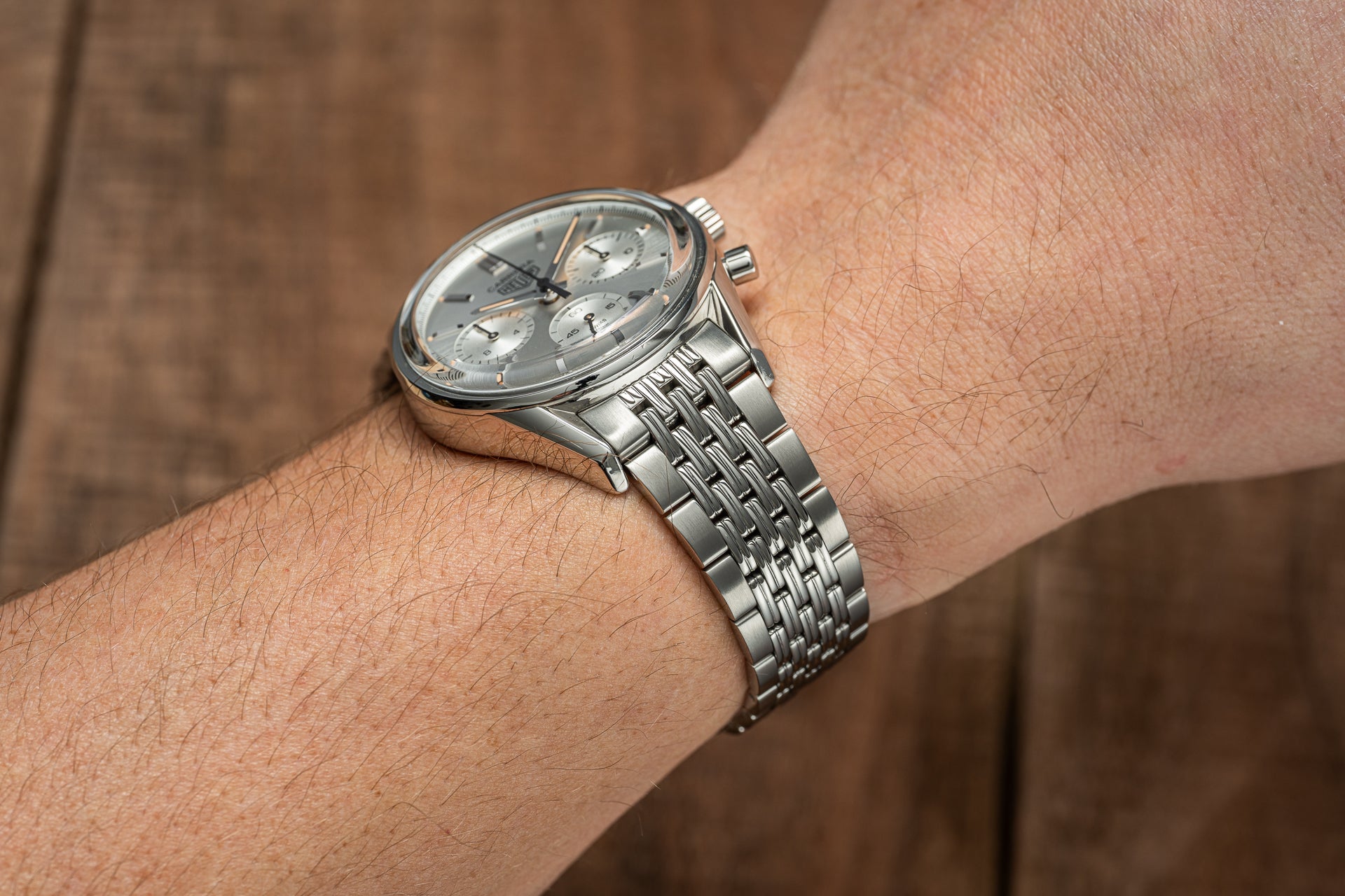 Silver chronograph watch with stainless steel Beads of Rice bracelet worn on wrist, gray dial with subdials