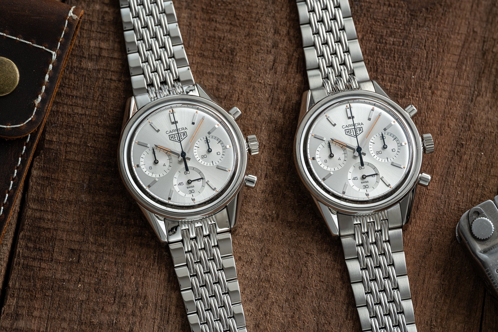 Two Tag Heuer Carrera chronograph watches with silver steel Beads of Rice bracelets on brown leather background