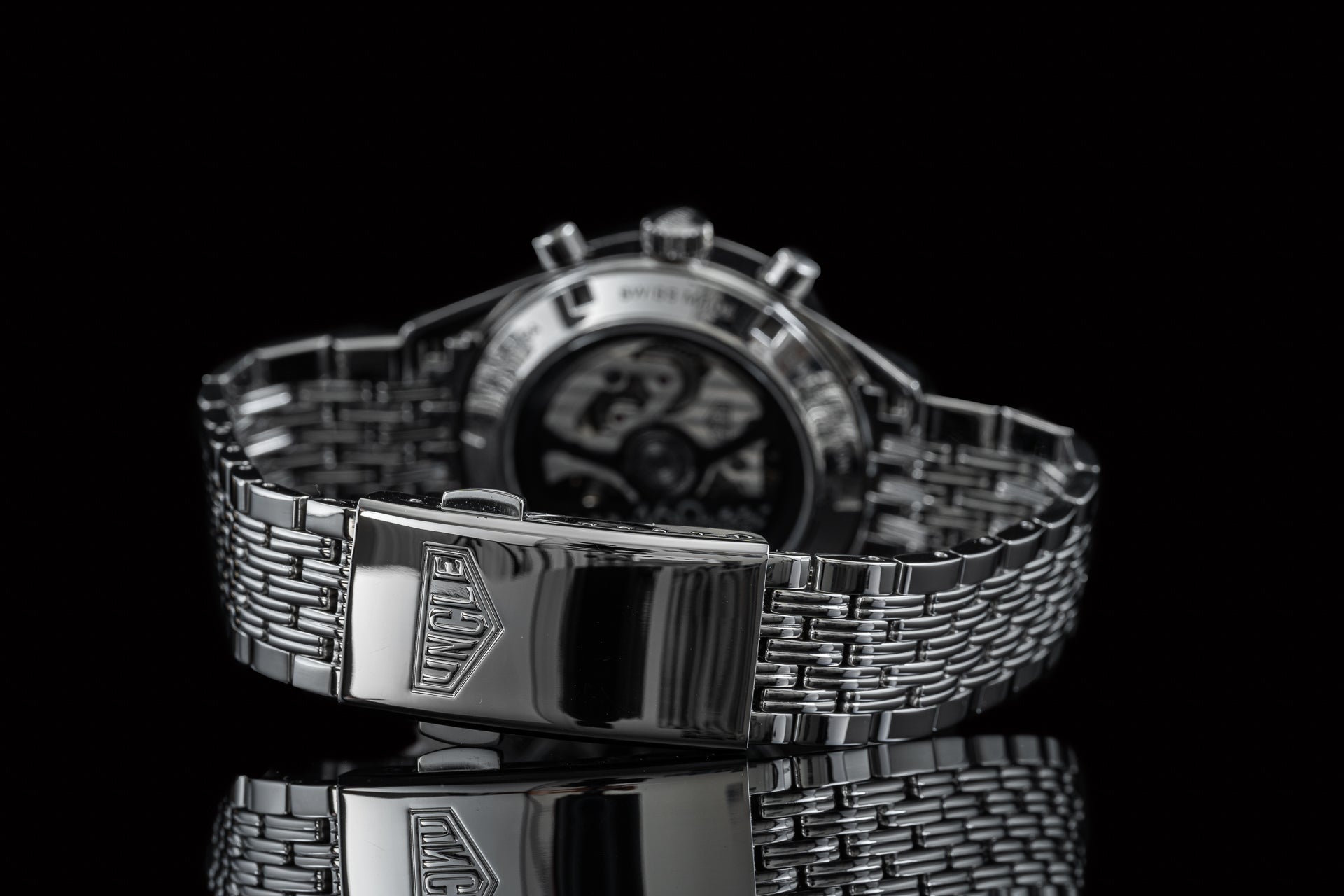 Stainless steel chronograph watch with beads of rice metal bracelet and fold-over clasp on black background