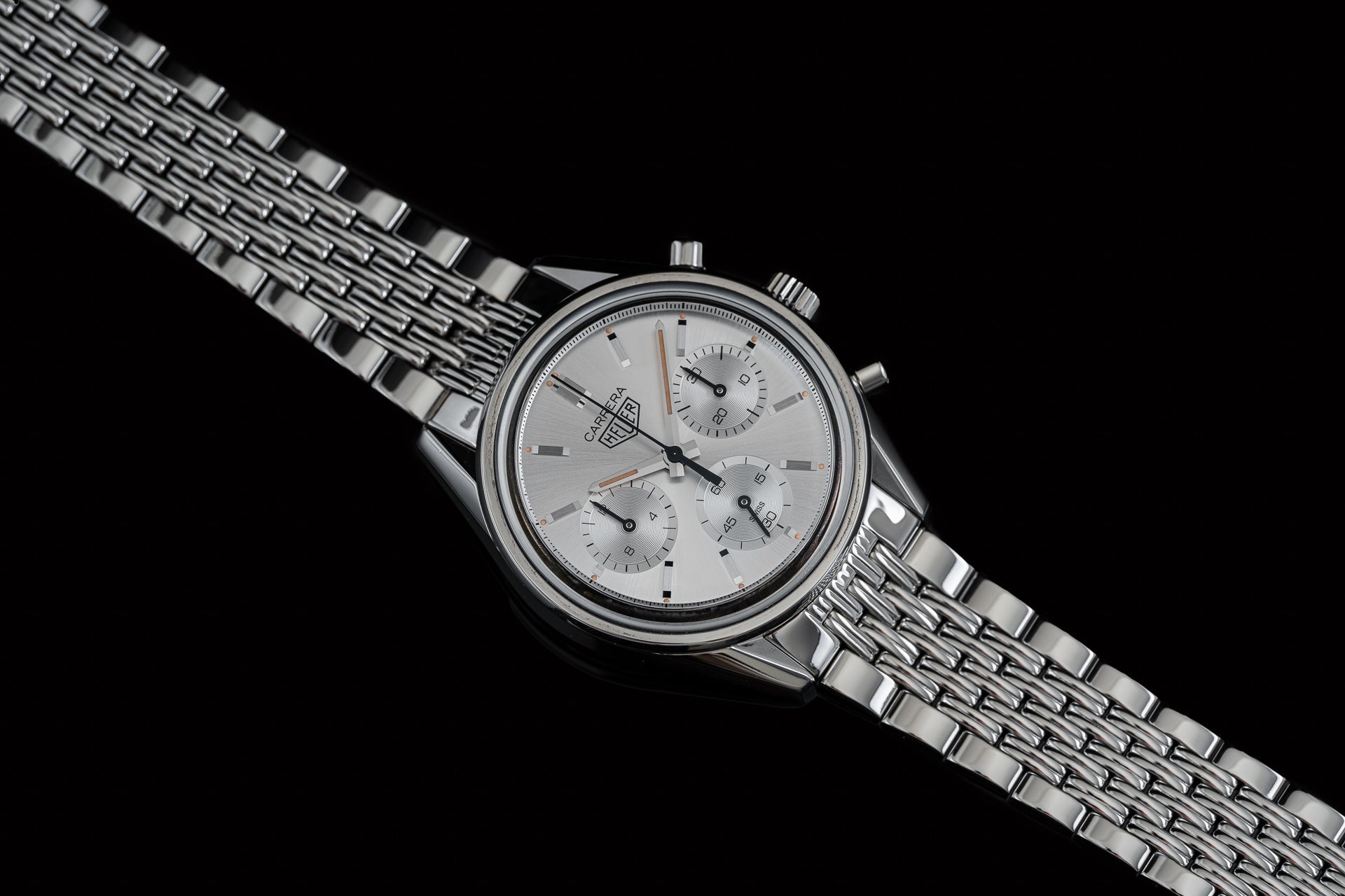 Stainless steel chronograph watch with silver dial and three subdials, featuring beads of rice metal bracelet on black background