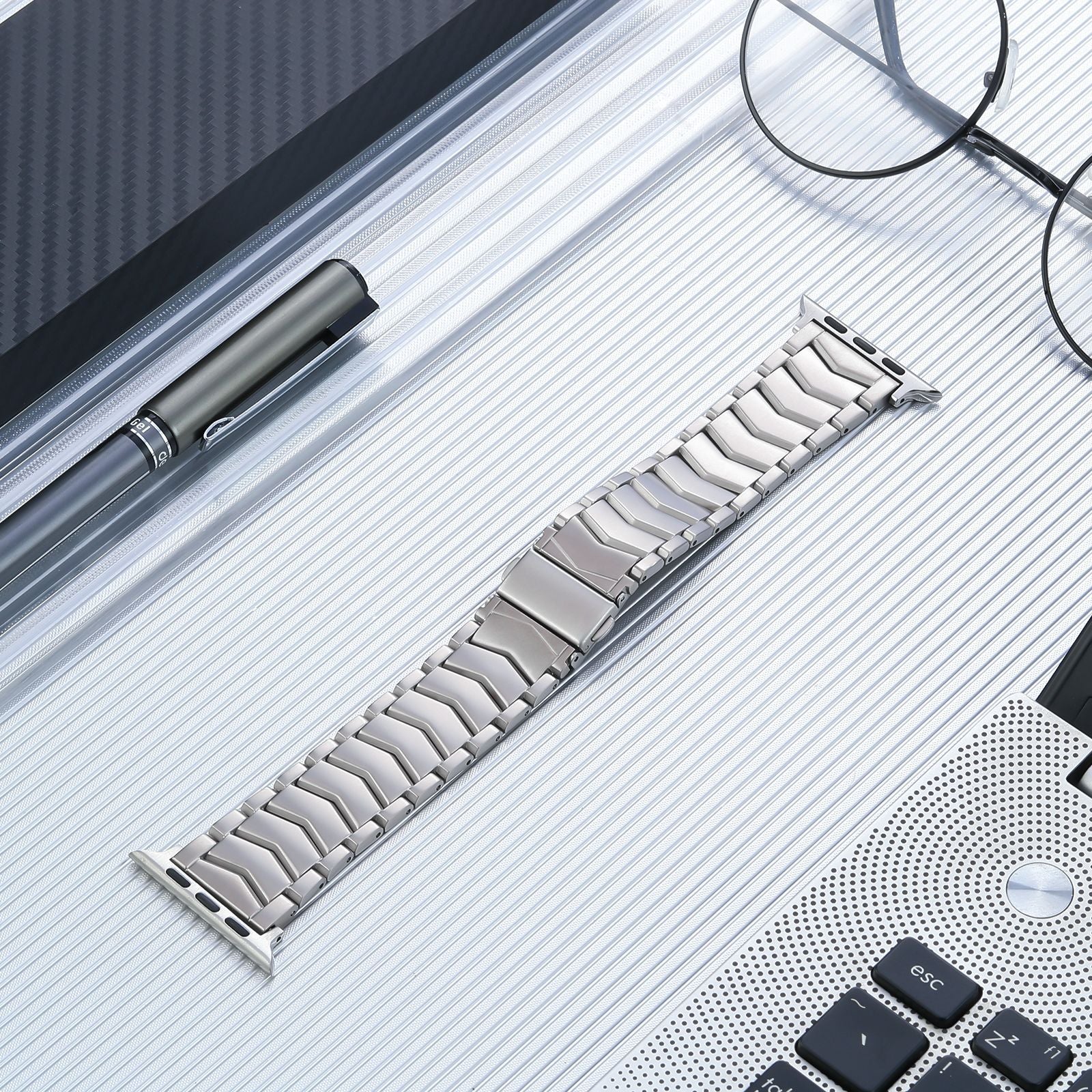 Titanium arched link bracelet for Apple Watch with polished silver finish displayed on striped surface