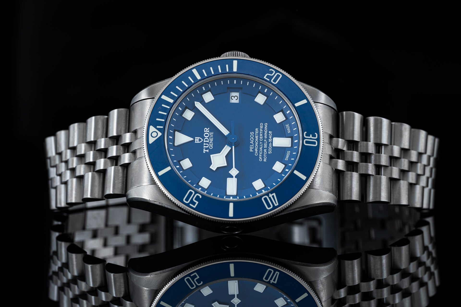 Tudor Pelagos 42mm stainless steel dive watch with blue dial, rotating bezel, and matching bracelet on black background