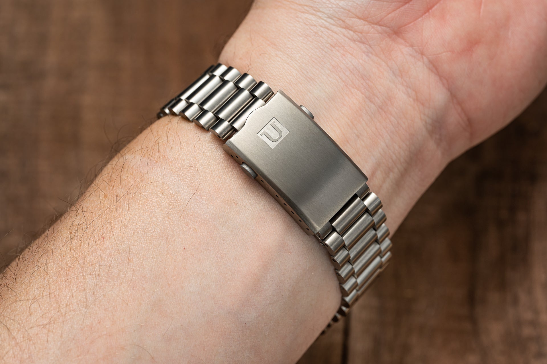 Stainless steel bracelet with solid links and engraved clasp worn on wrist, compatible with Tudor Pelagos 42mm watches