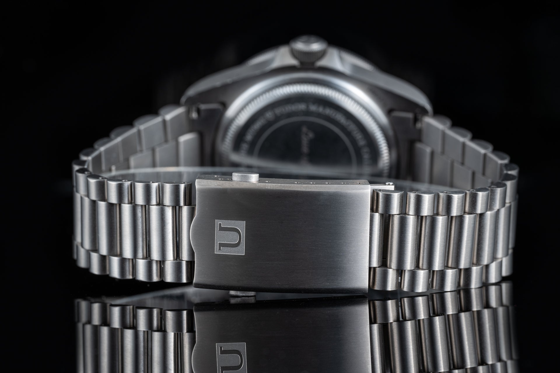 Stainless steel bracelet with deployant clasp for Tudor Pelagos 42mm watch, detailed front view on black background