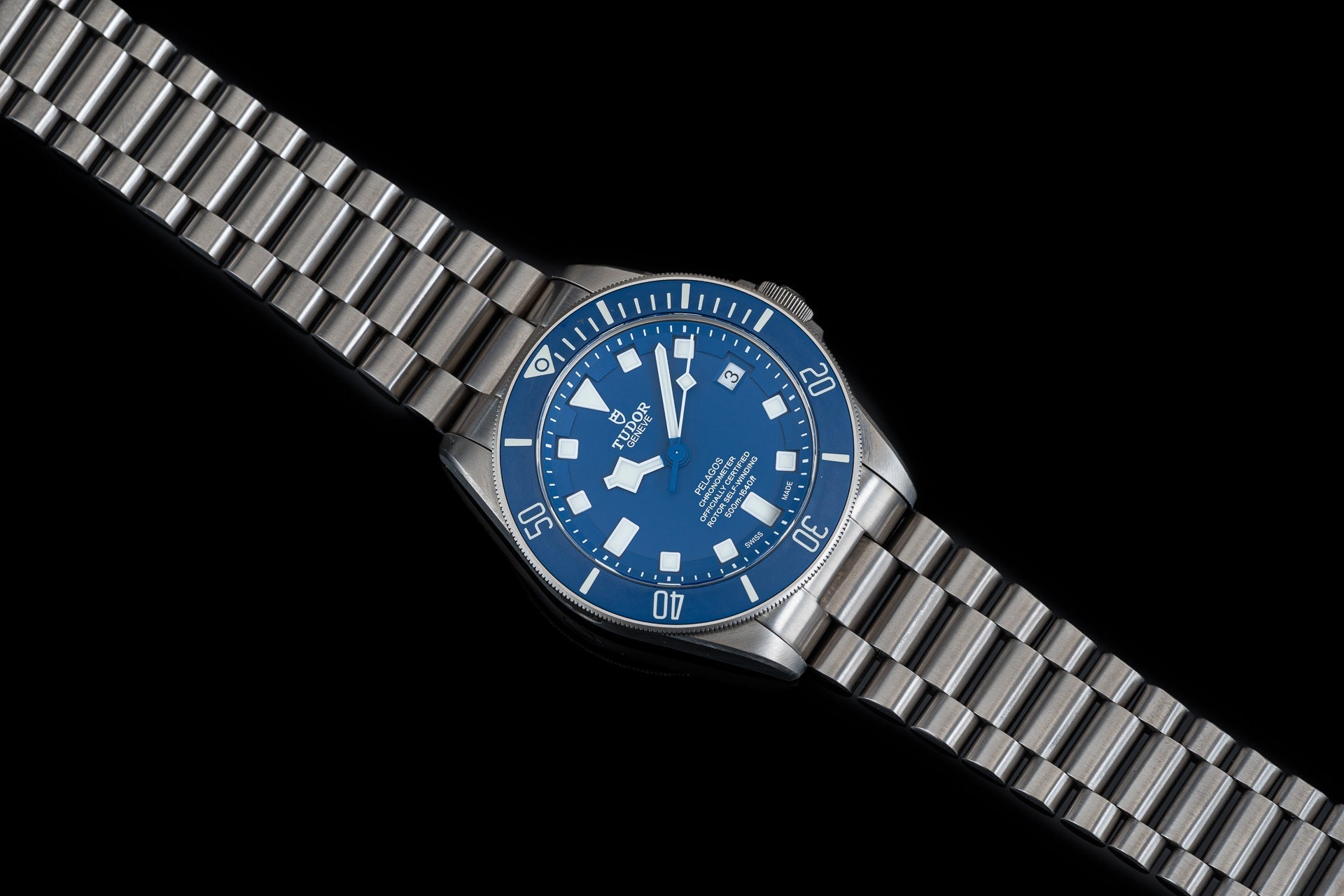 Stainless steel titanium bracelet with clasp for Tudor Pelagos 42mm dive watch, shown on blue dial timepiece against black background