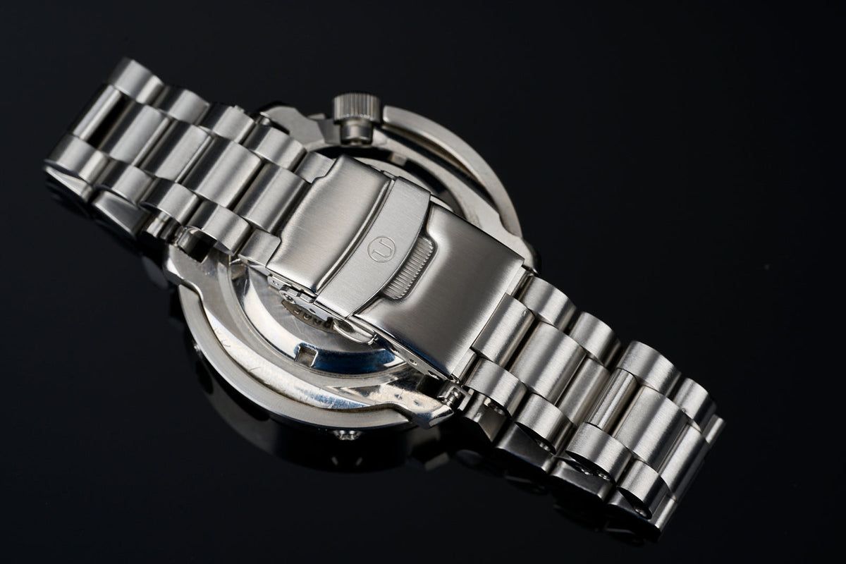Stainless steel straight end watch bracelet 22mm with polished links and deployment clasp on black background