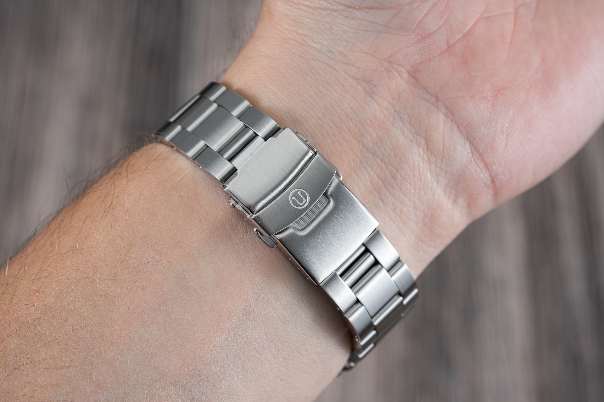 Stainless steel watch bracelet with solid end links worn on wrist, showing brushed and polished finish suitable for Seiko dive watches