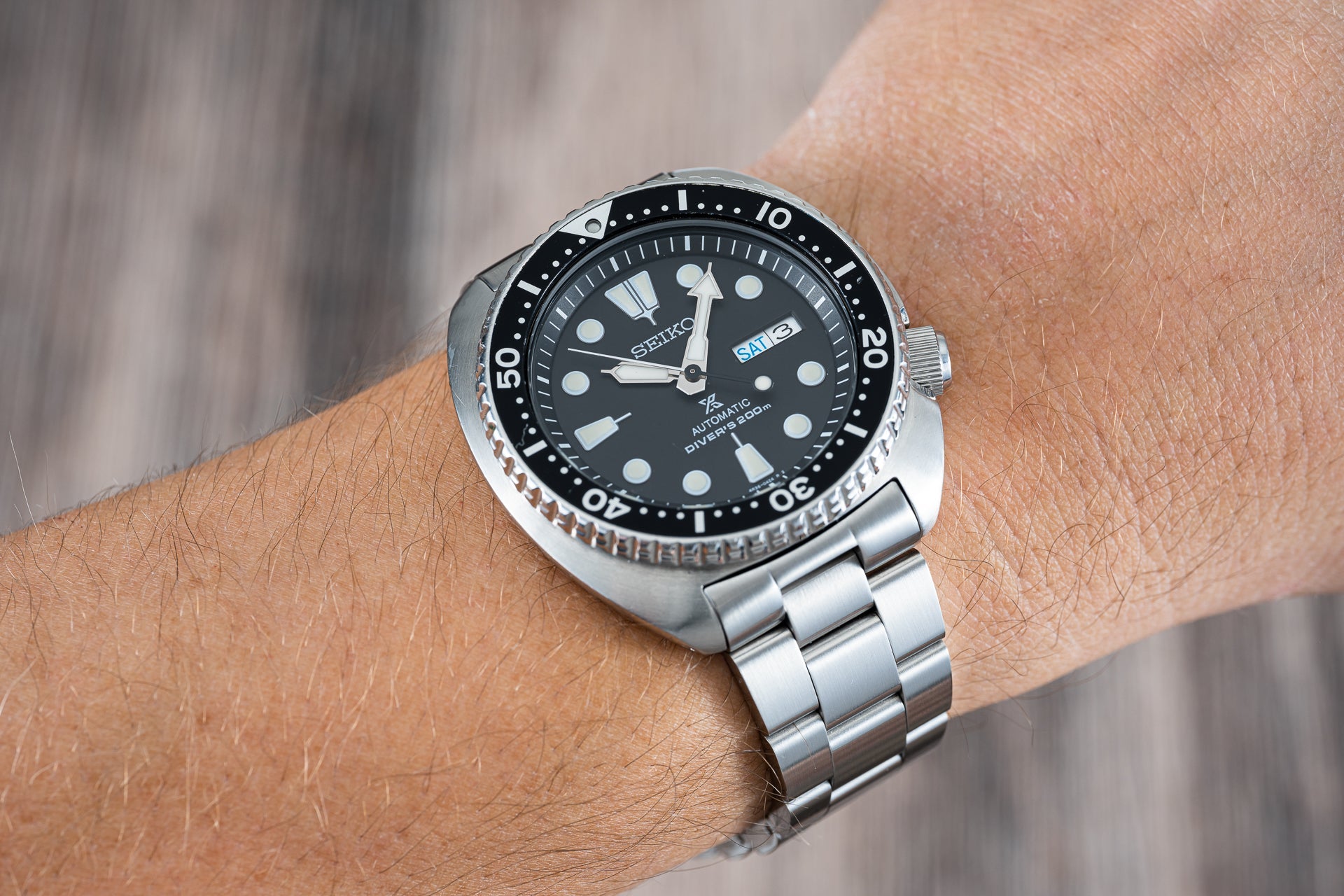 Seiko automatic dive watch with black dial, stainless steel bracelet and rotating bezel on wrist